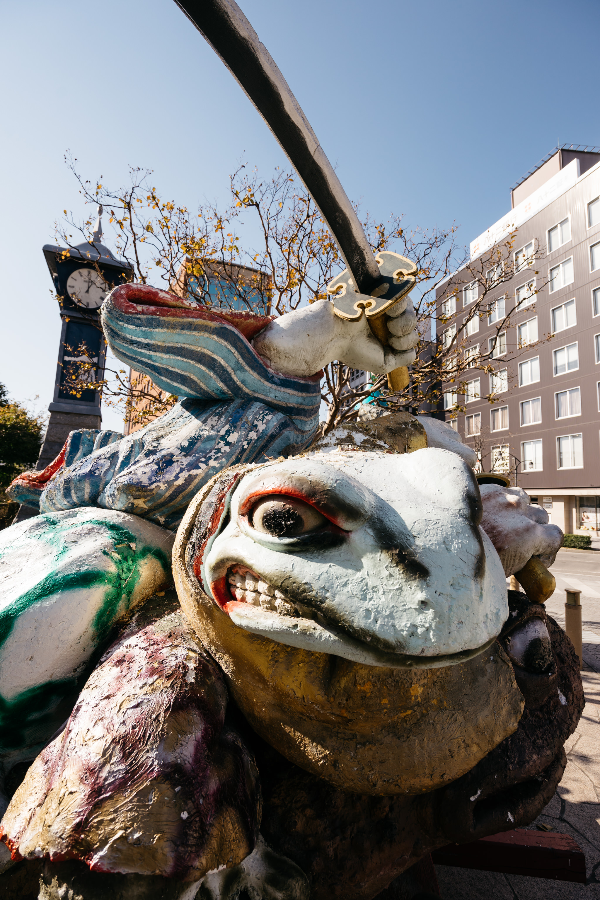 Weathered statue of a samurai atop a giant turtle, holding a sword.