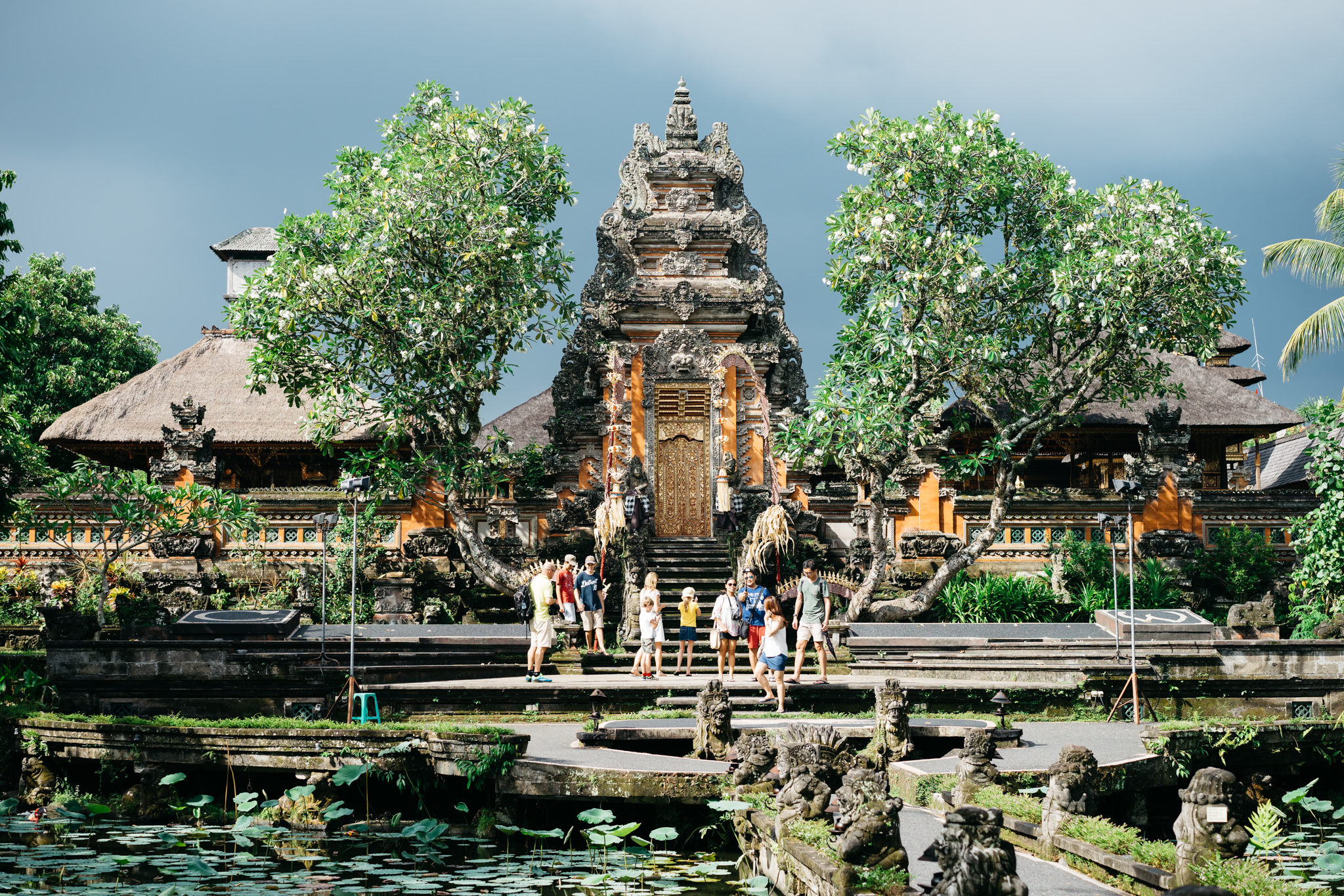 Tourists stand in front of a Balinese temple.
