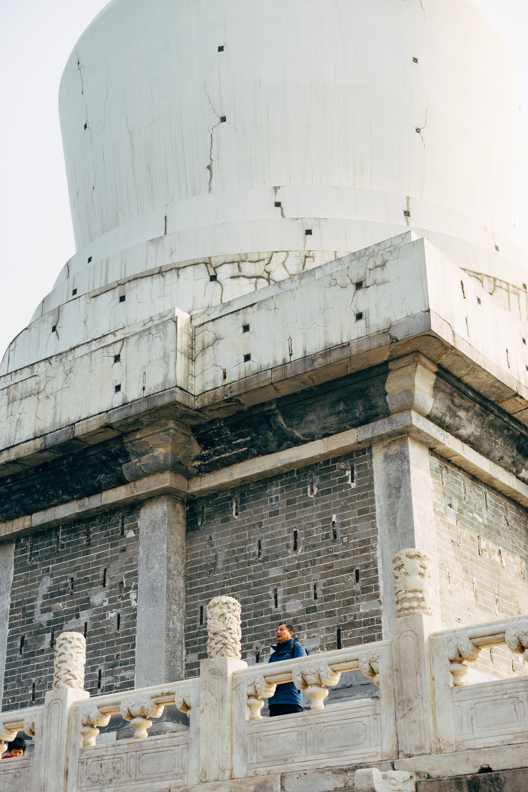 Person standing by a weathered white pagoda in Beihai Park, Beijing.