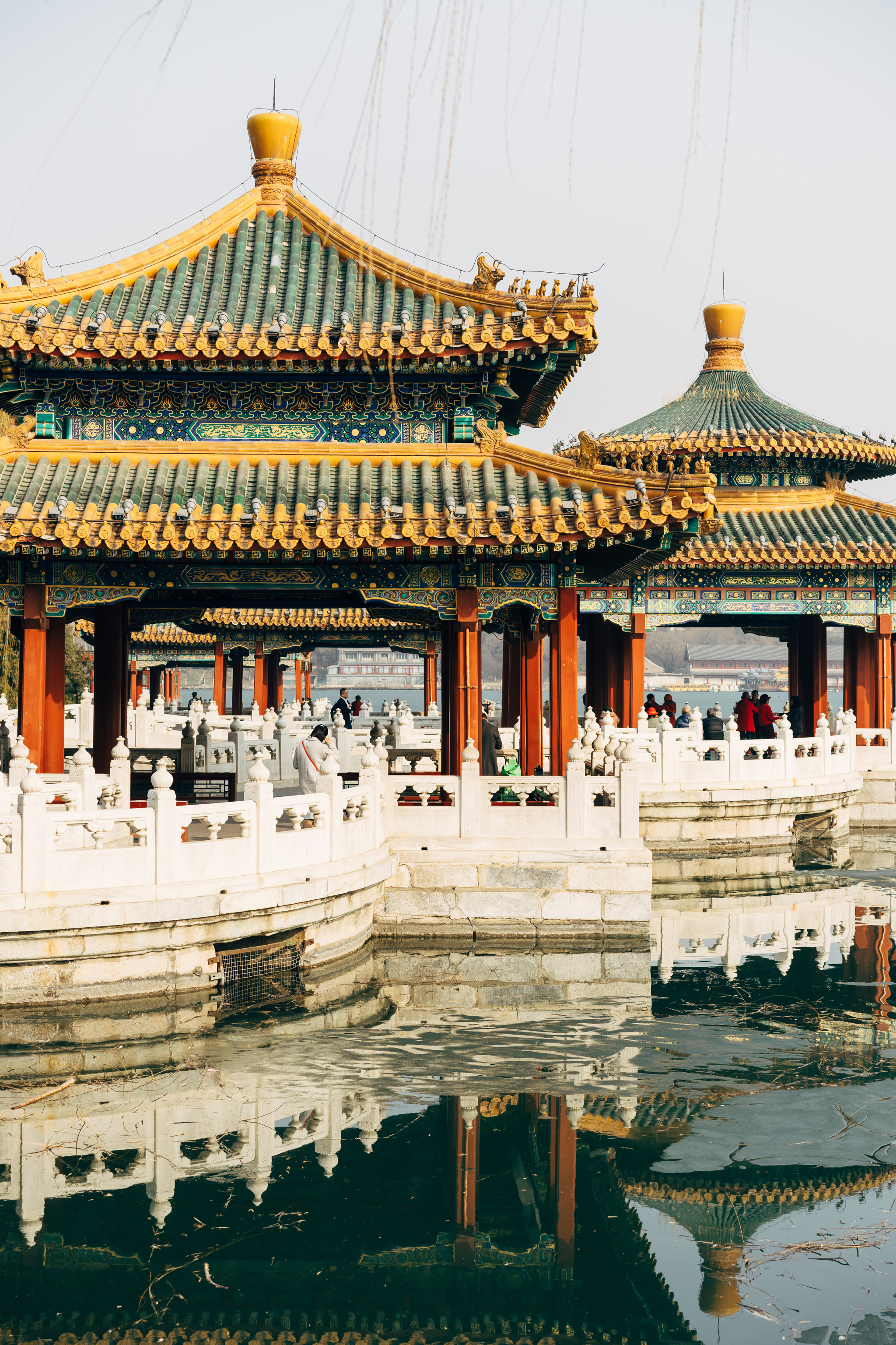 Two ornate Chinese pavilions reflected in a calm body of water.
