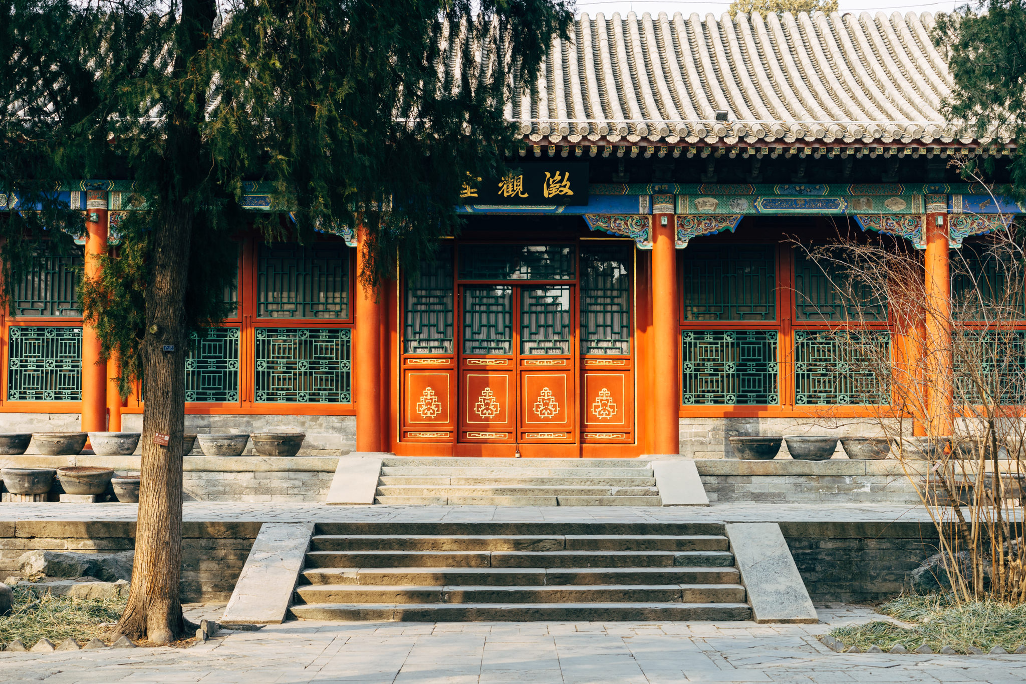 Traditional red Chinese building with ornate details and stone steps.