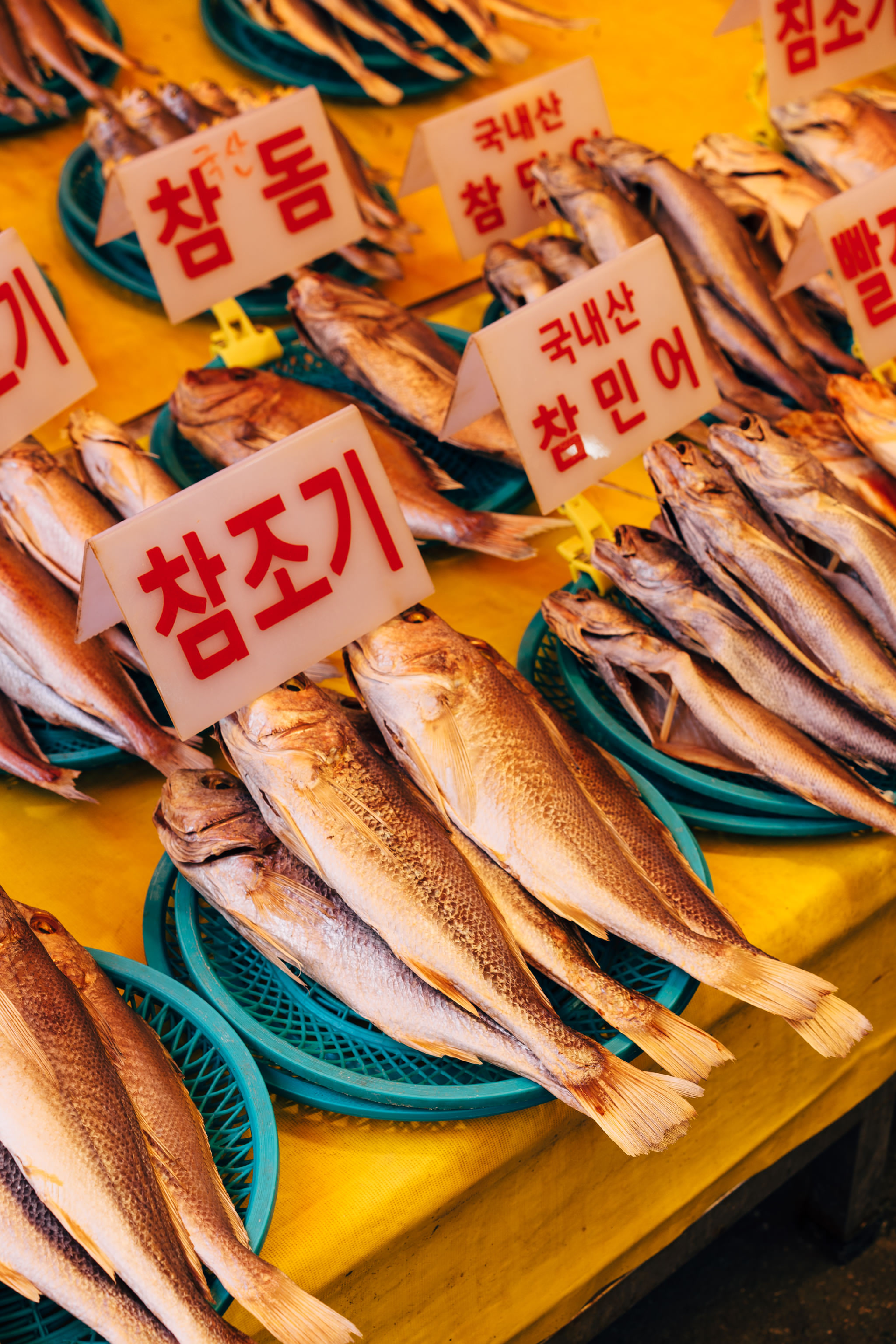 Dried fish on display at Busan fish market with Korean price signs.