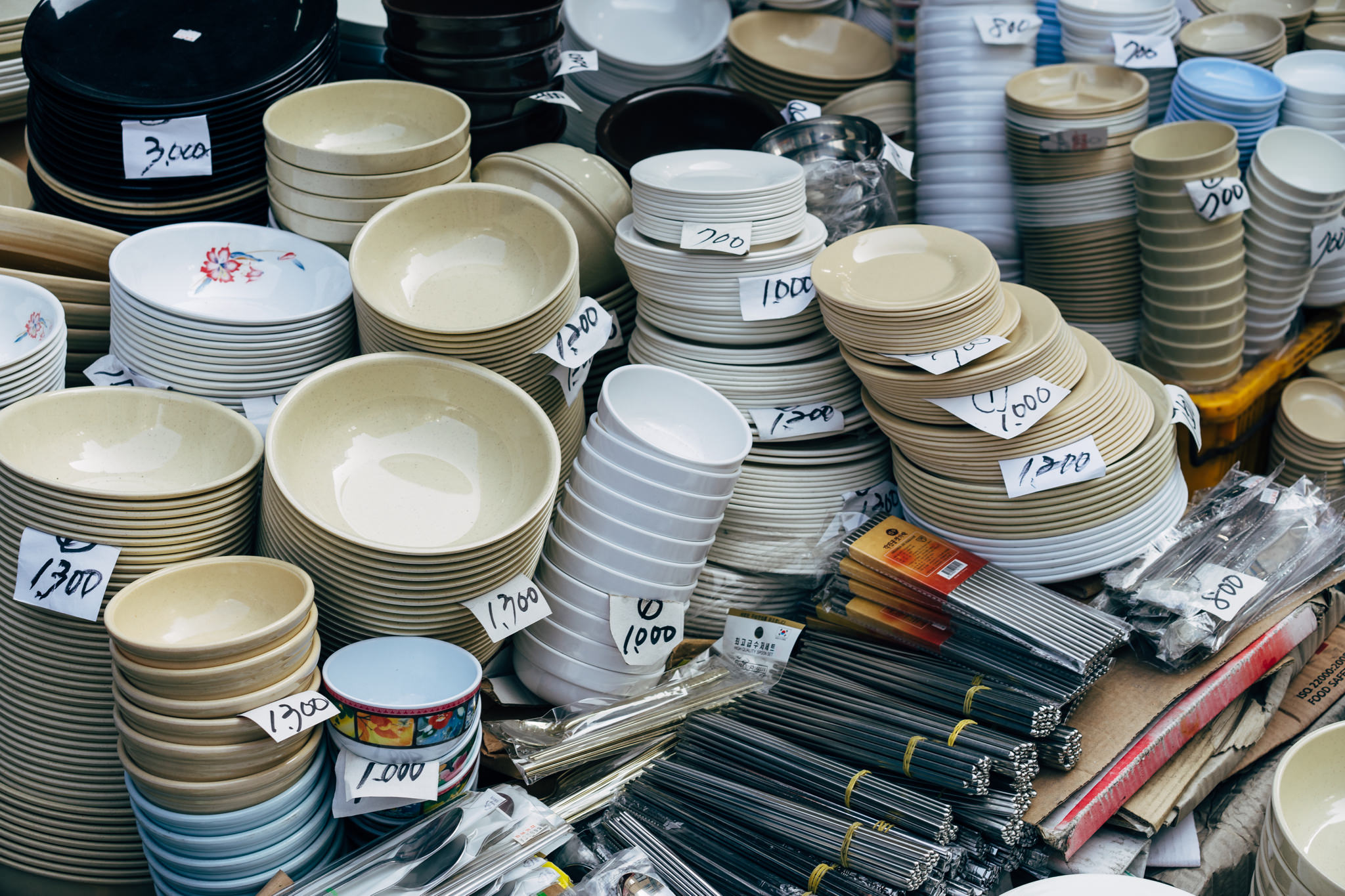 Stacks of bowls and plates for sale at a Busan market.