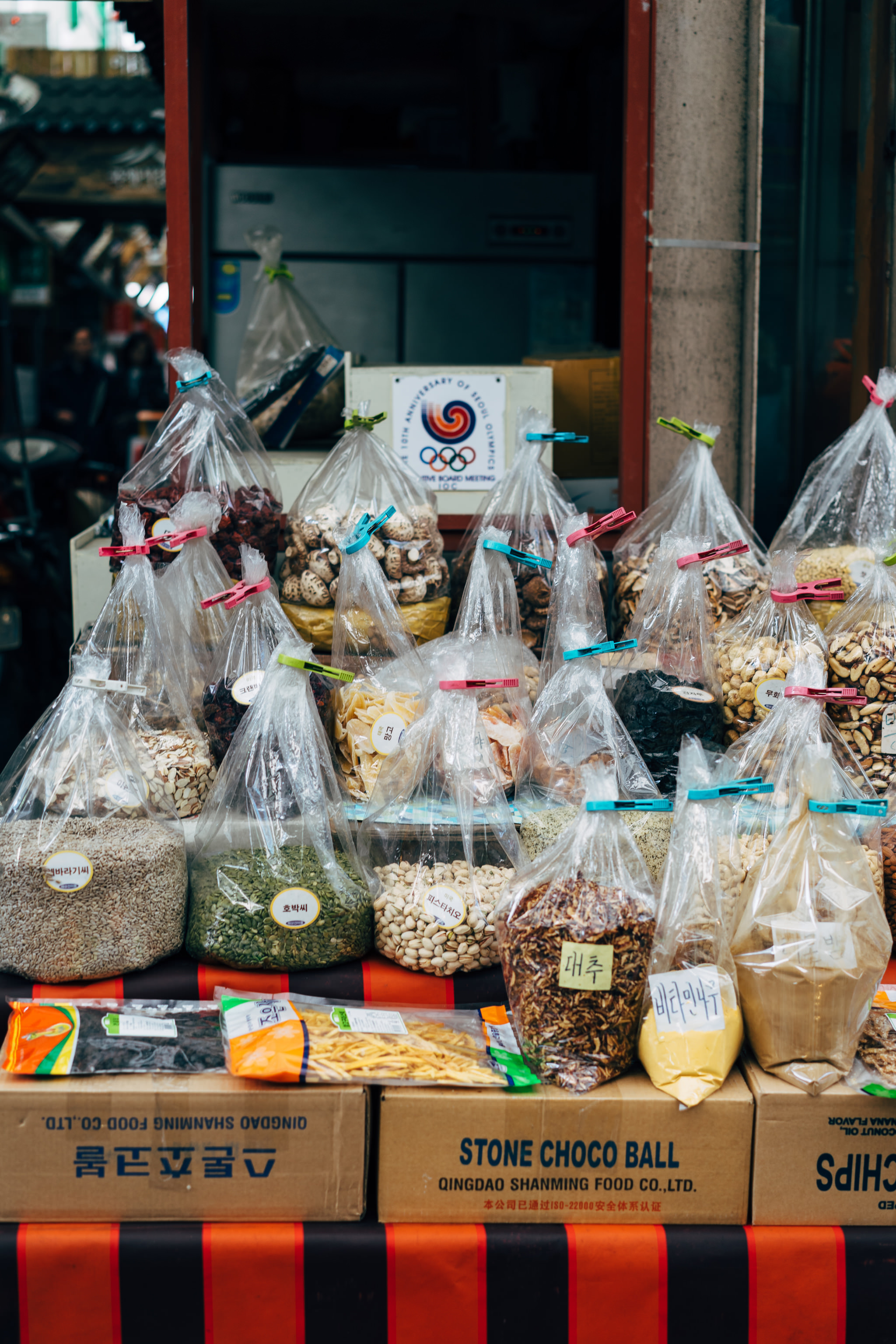 Busan market stall with various dried goods and nuts in plastic bags.