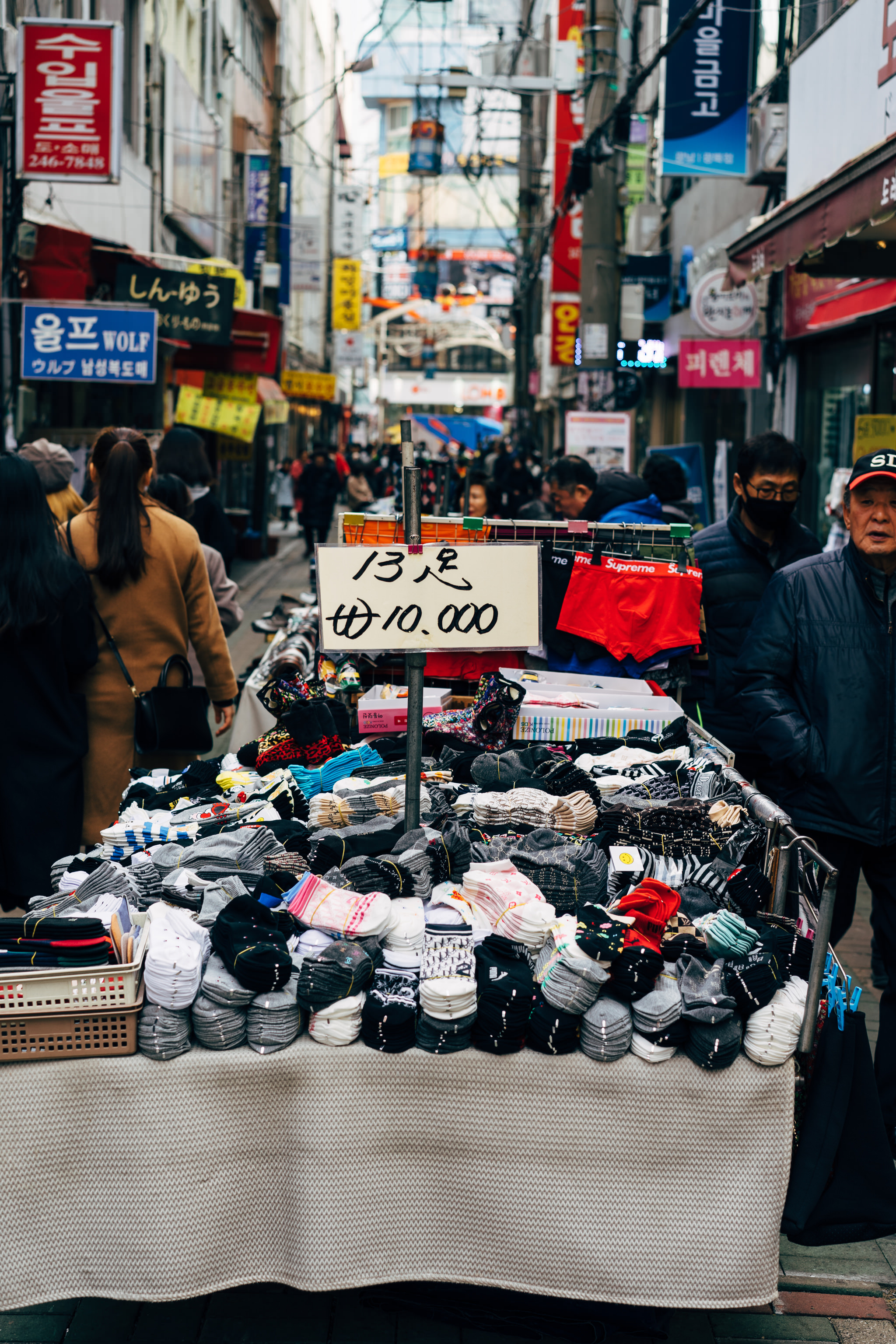 Busan market stall selling socks; sign indicates 13 pairs for ₩10,000.