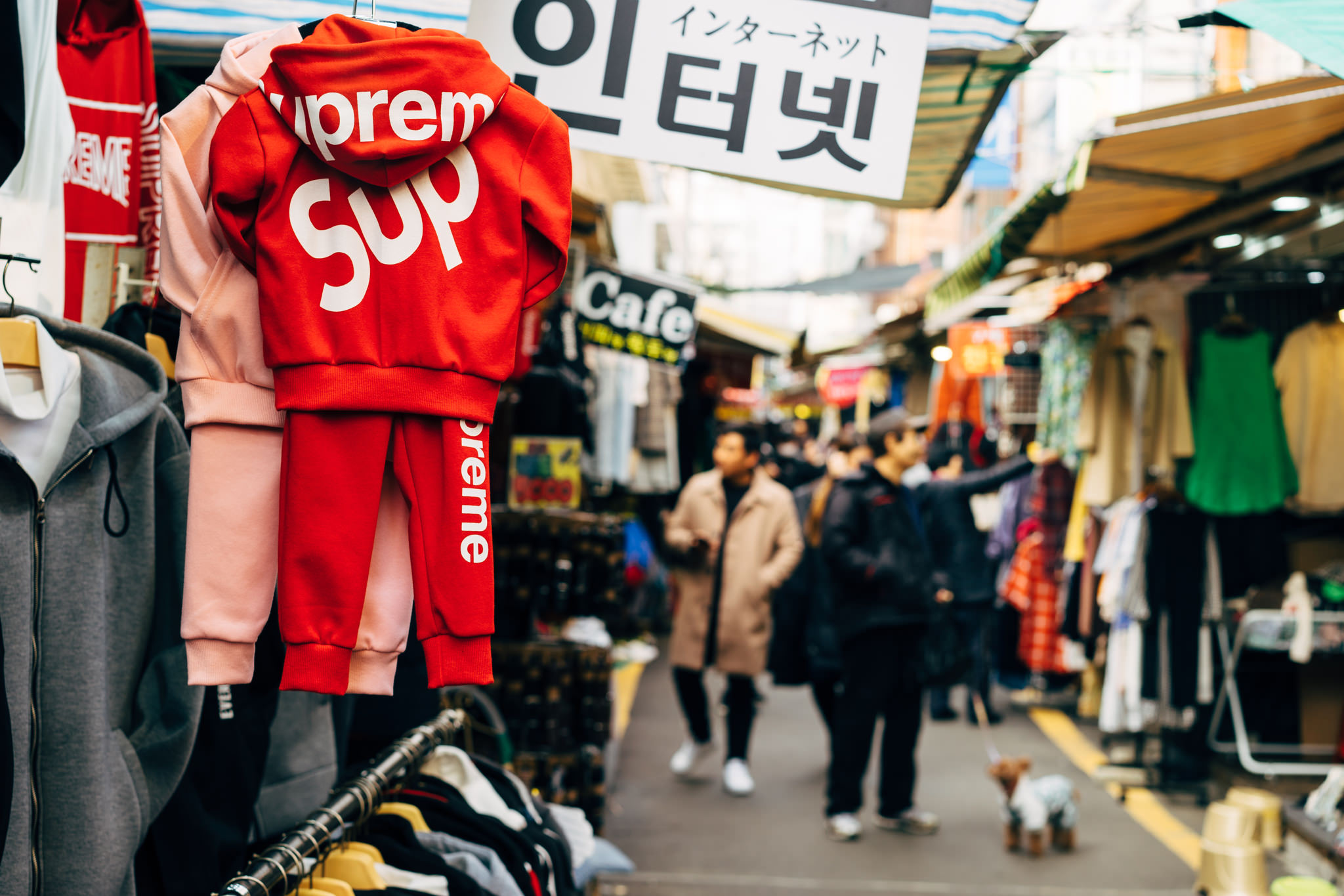 Red Supreme children's tracksuit on display in a Busan market.