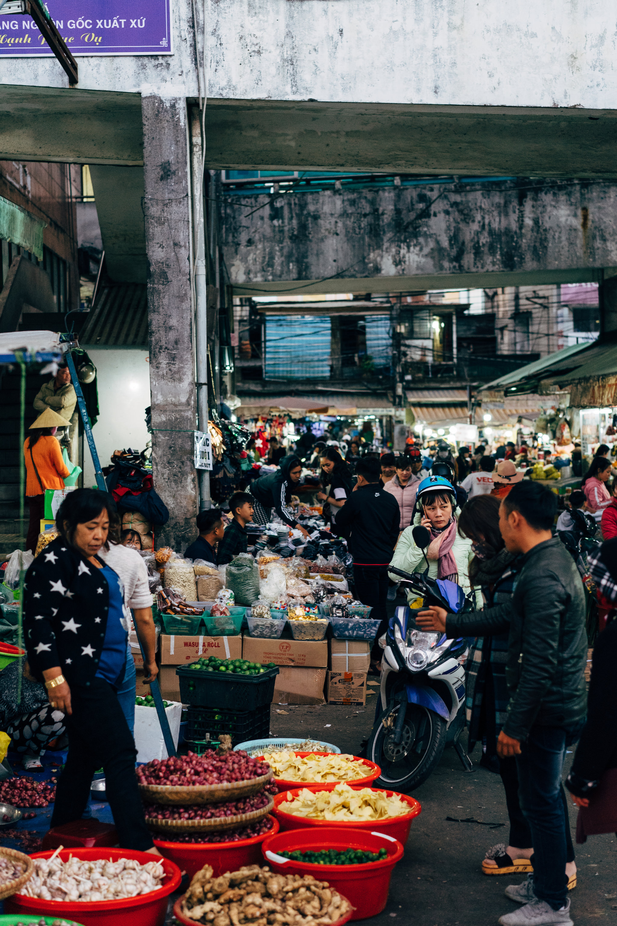 Busy Da Lat market with people shopping and produce on display.