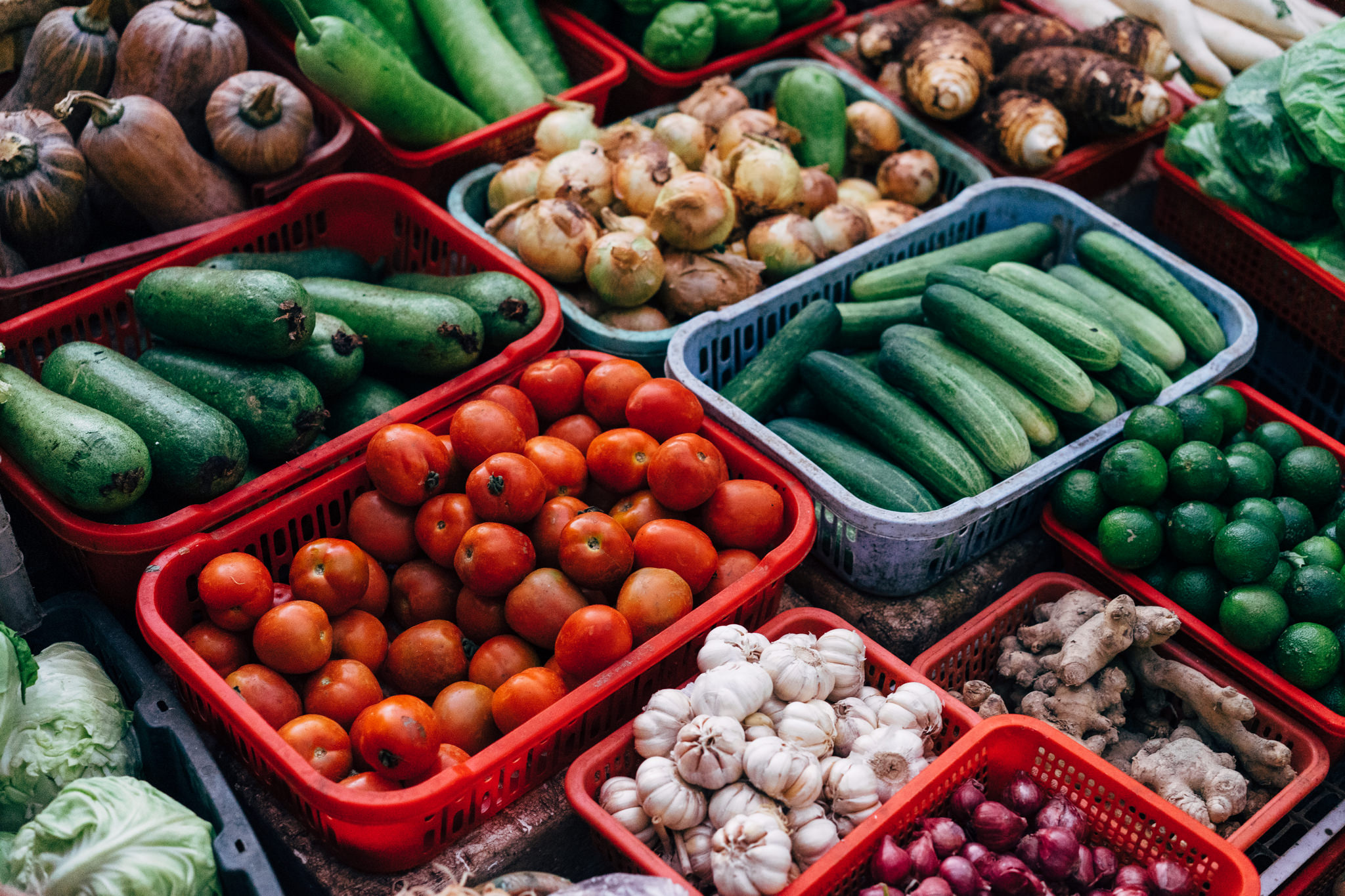 Da Lat market produce in red and blue crates.