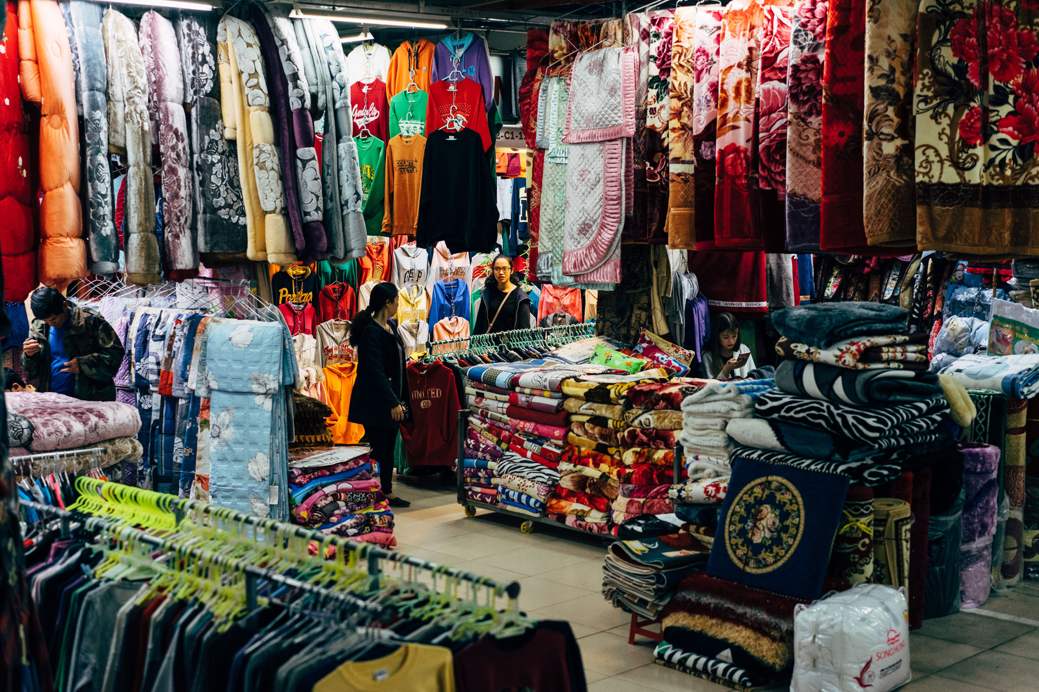 Da Lat market with clothing and blankets for sale.