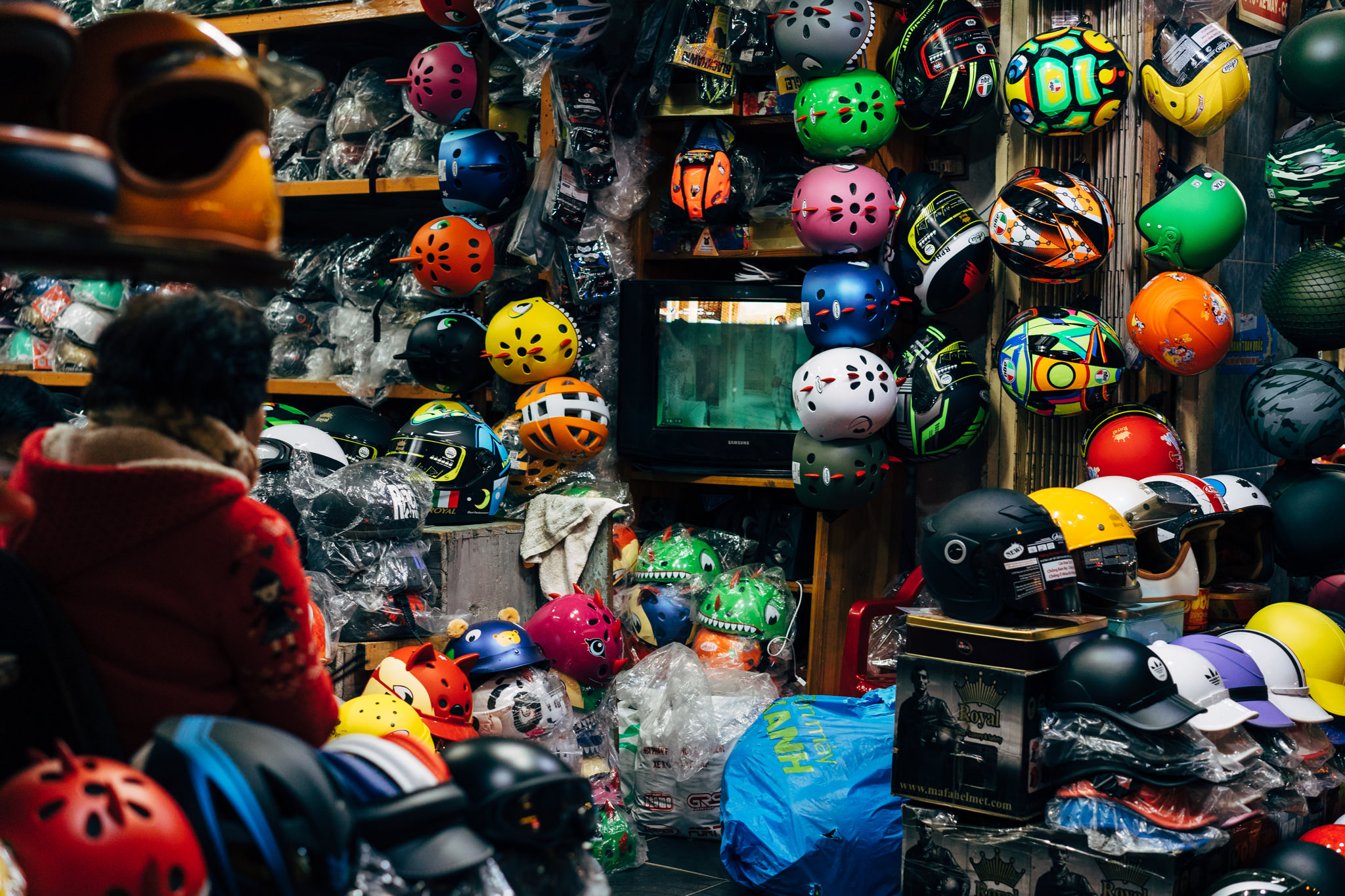 A Da Lat market stall overflowing with colorful helmets of various sizes and styles.