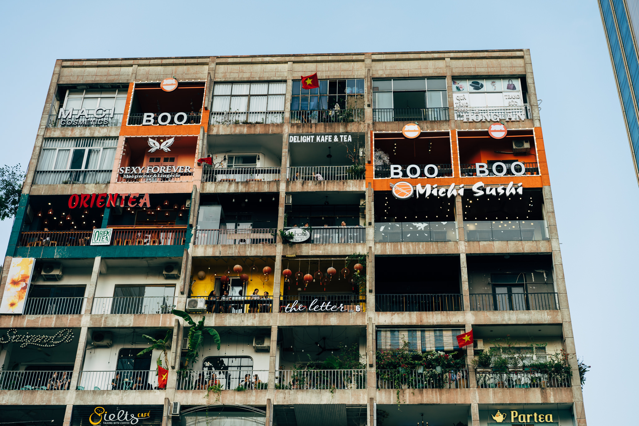 Multi-story building in Ho Chi Minh City with numerous businesses on each floor, including restaurants and shops.