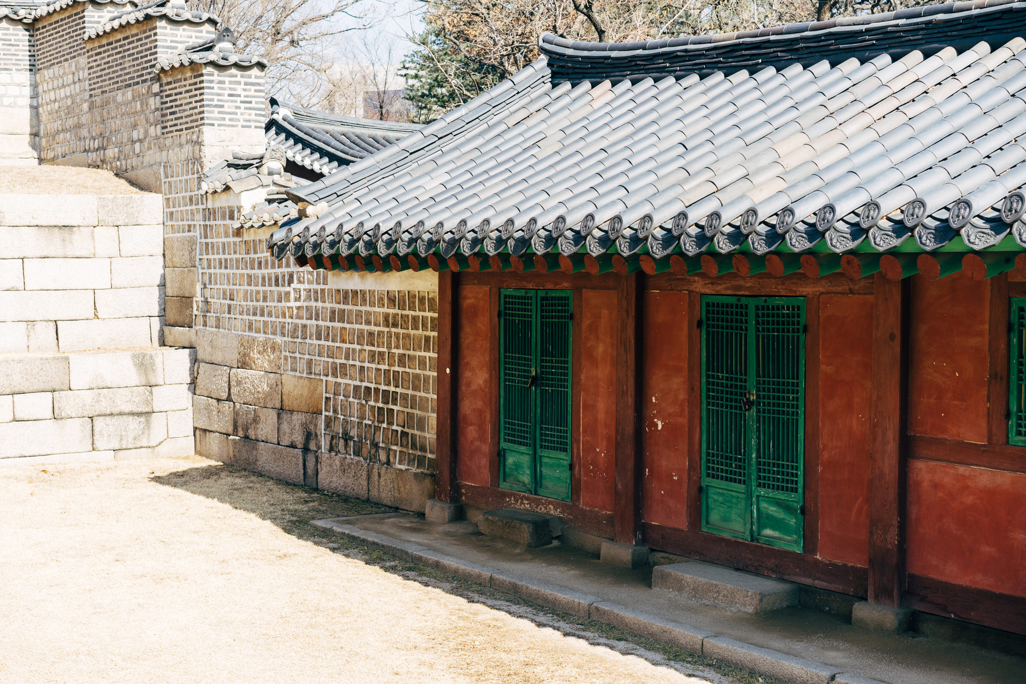 Jongmyo Shrine in Seoul, showing a traditional building with green doors and a grey tiled roof.