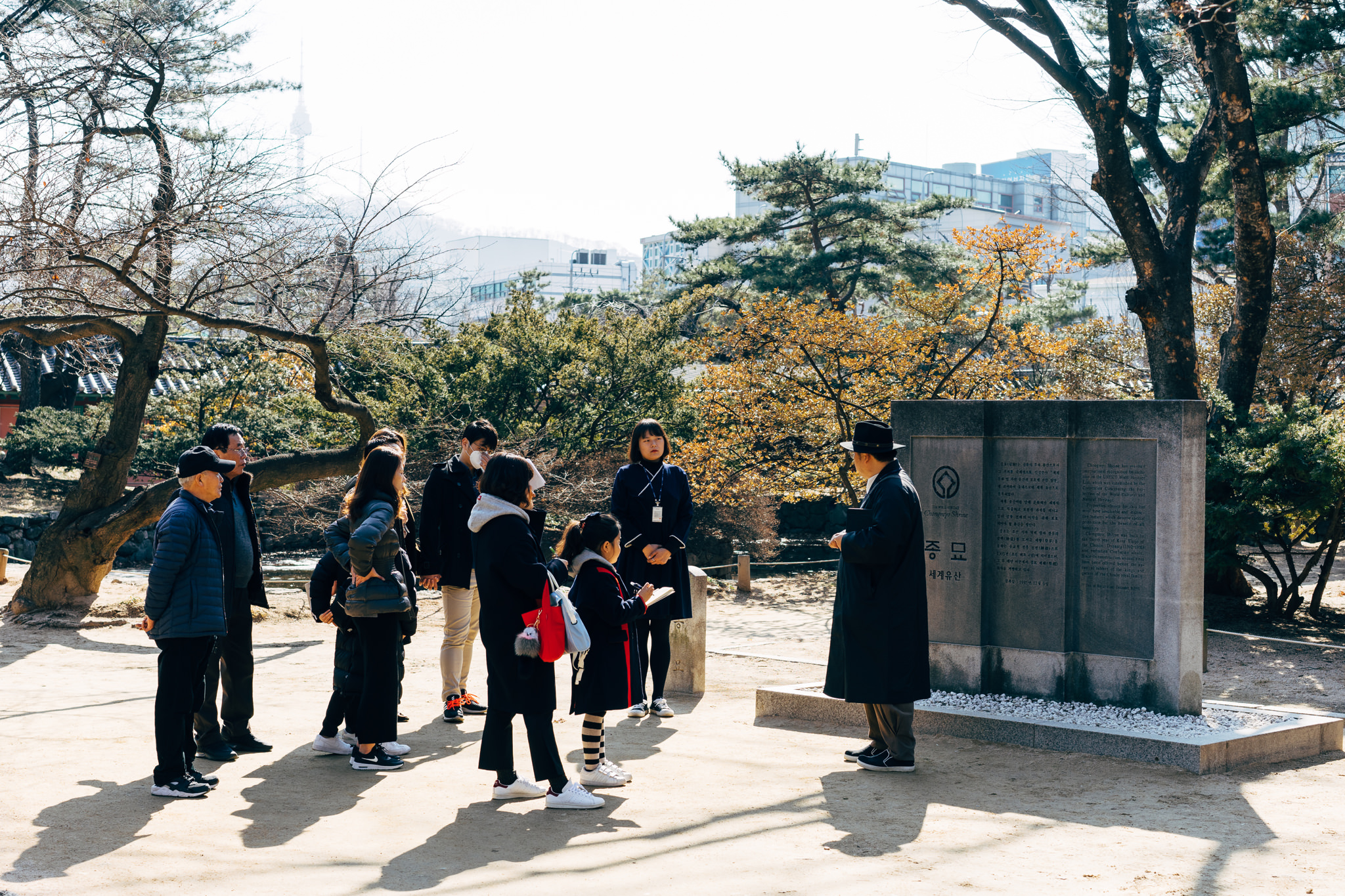 Tour group listening to a guide at Jongmyo Shrine in Seoul.