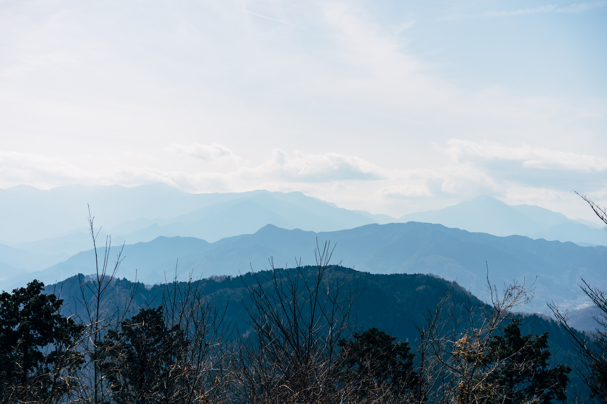 Mount Takao, Japan: Distant mountain range under a partly cloudy sky.