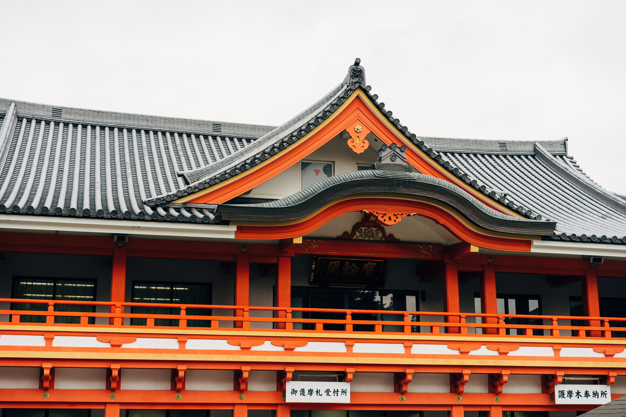Close-up of Kongo-ji Temple's orange and gray roof and upper story.