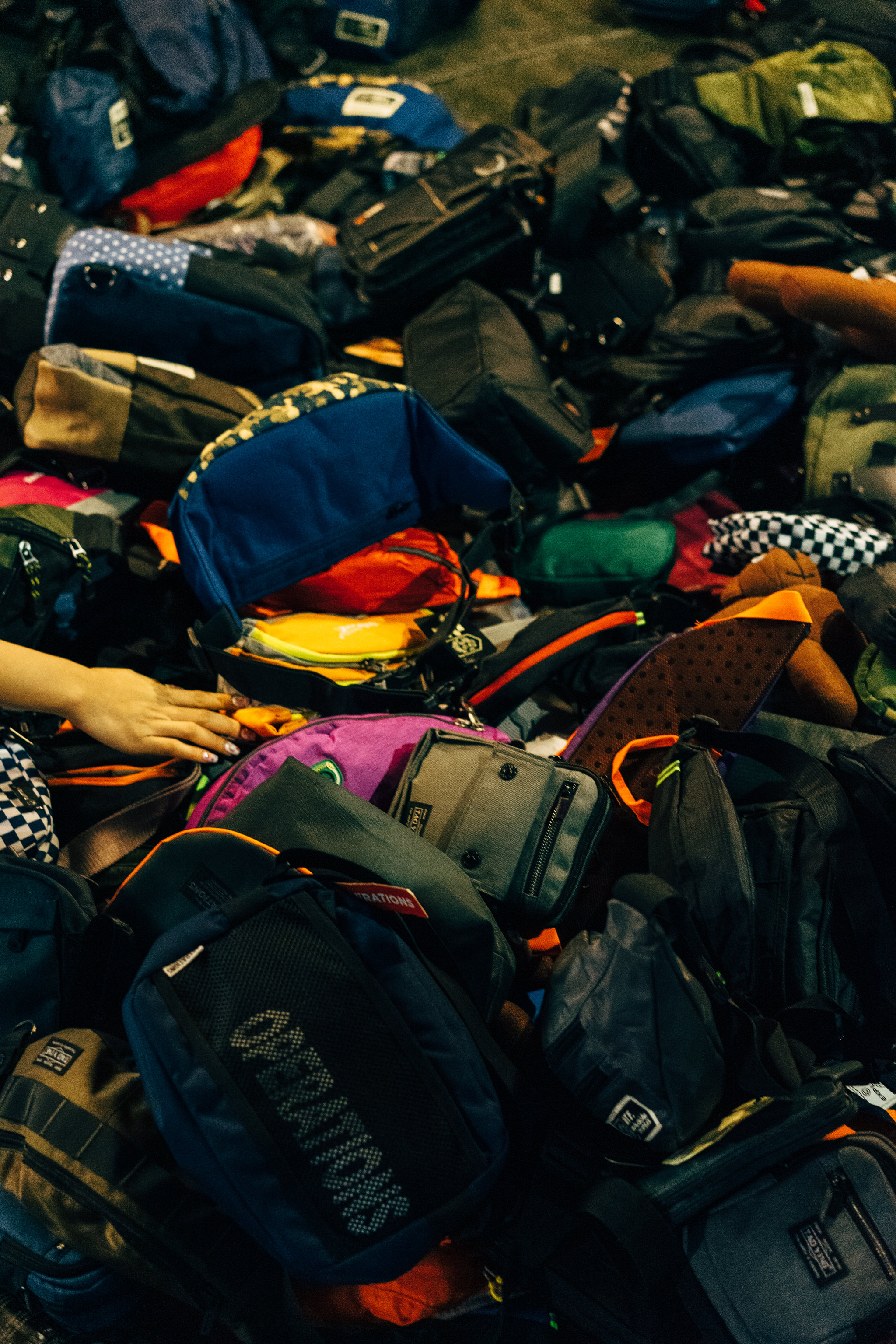A pile of various bags and backpacks in a Bangkok market.