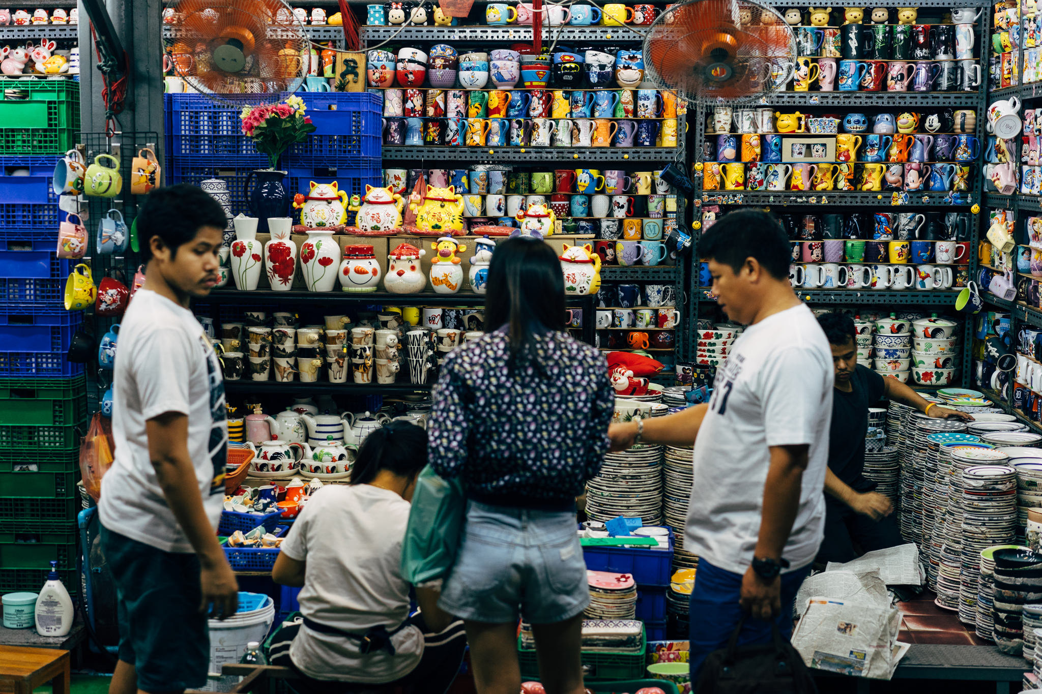 Bangkok market stall filled with colorful mugs and dishes.