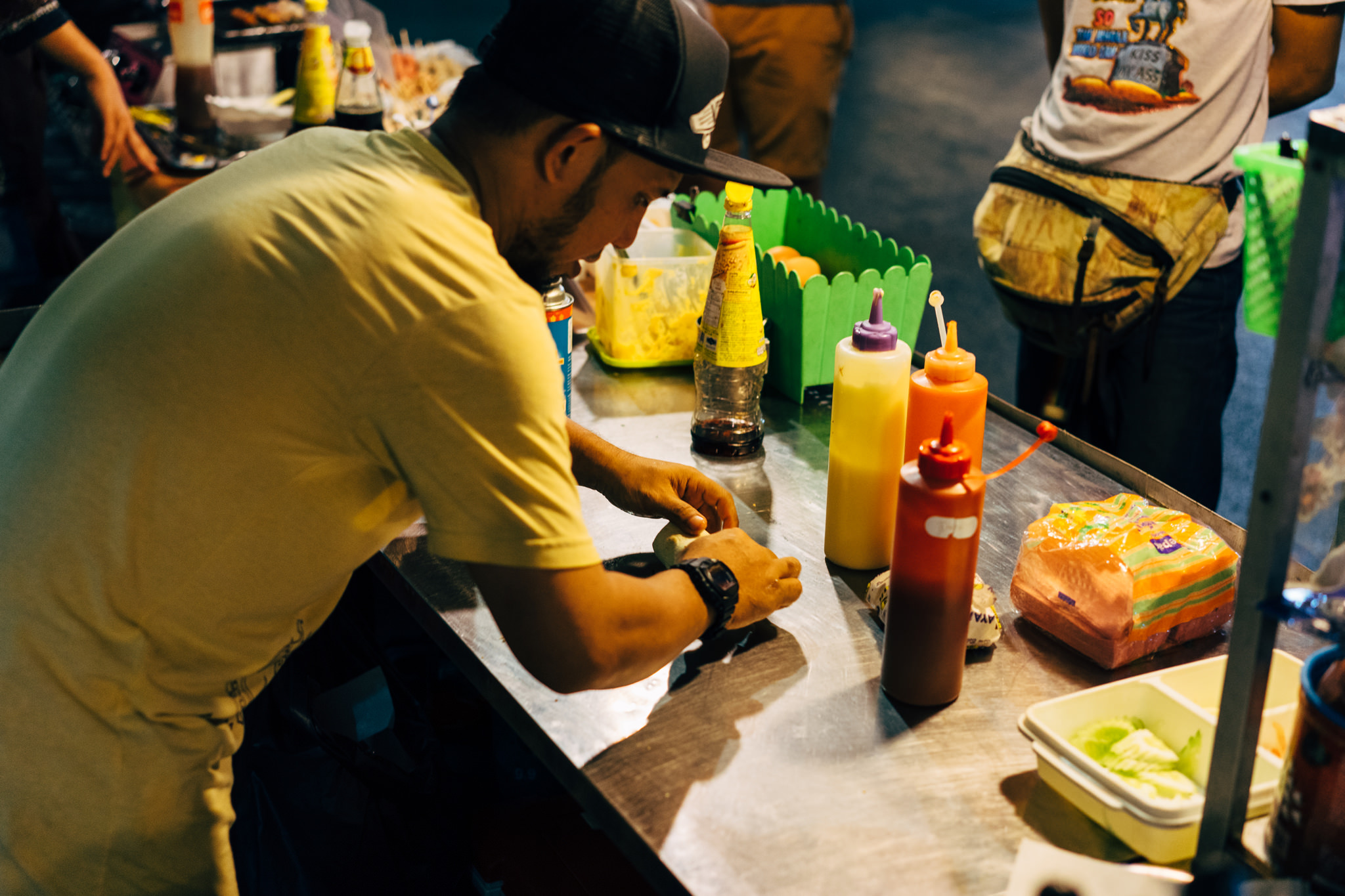 Person preparing food at a Bangkok market.