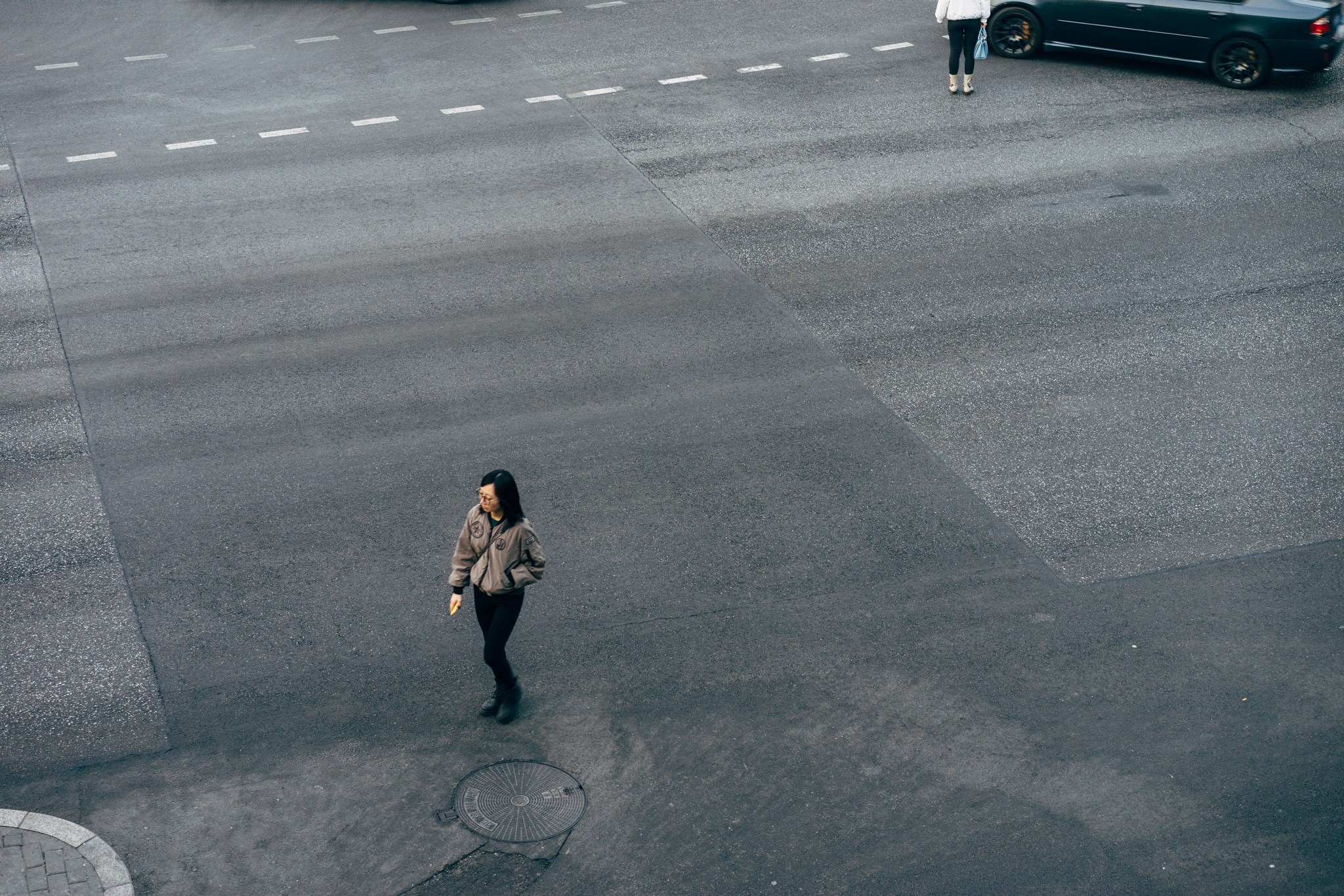 A woman walks across a Beijing street intersection.