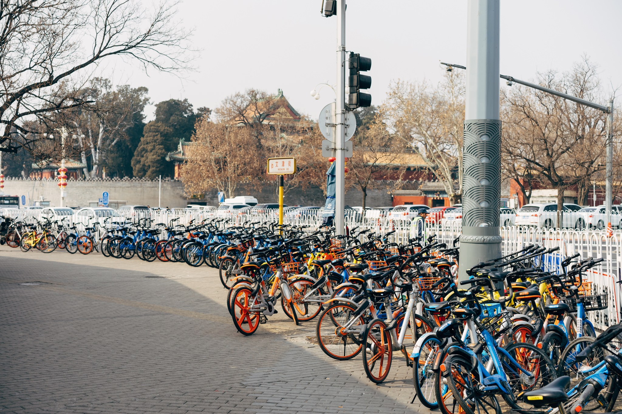 Rows of blue and orange shared bicycles parked in Beijing, China.