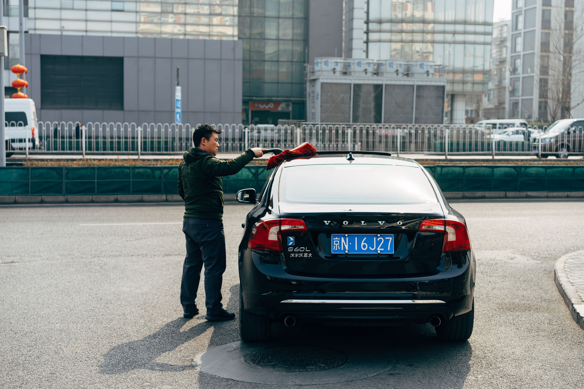 Man washing black Volvo car.
