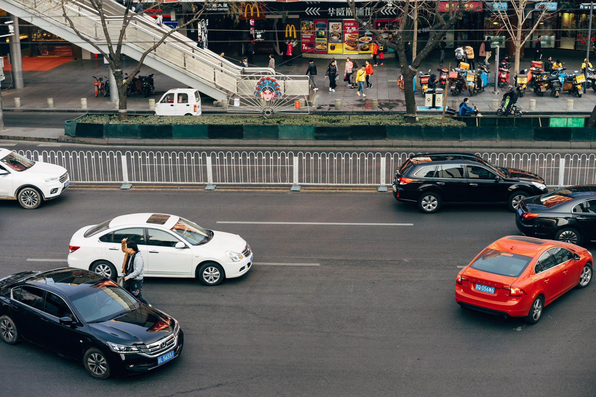 Beijing street scene with cars and pedestrians near a McDonald's.