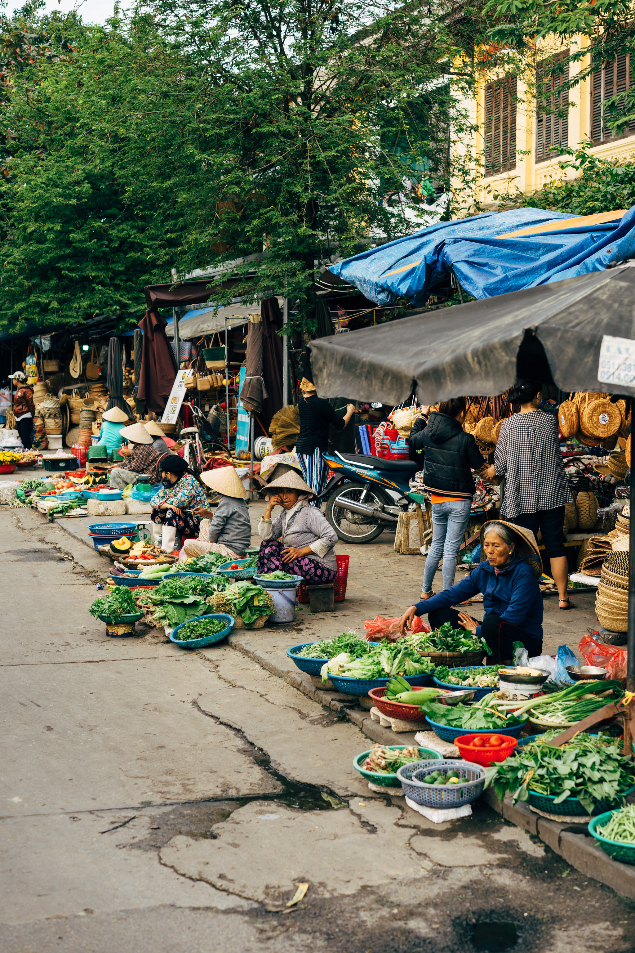 Hoi An street market vendors selling produce.