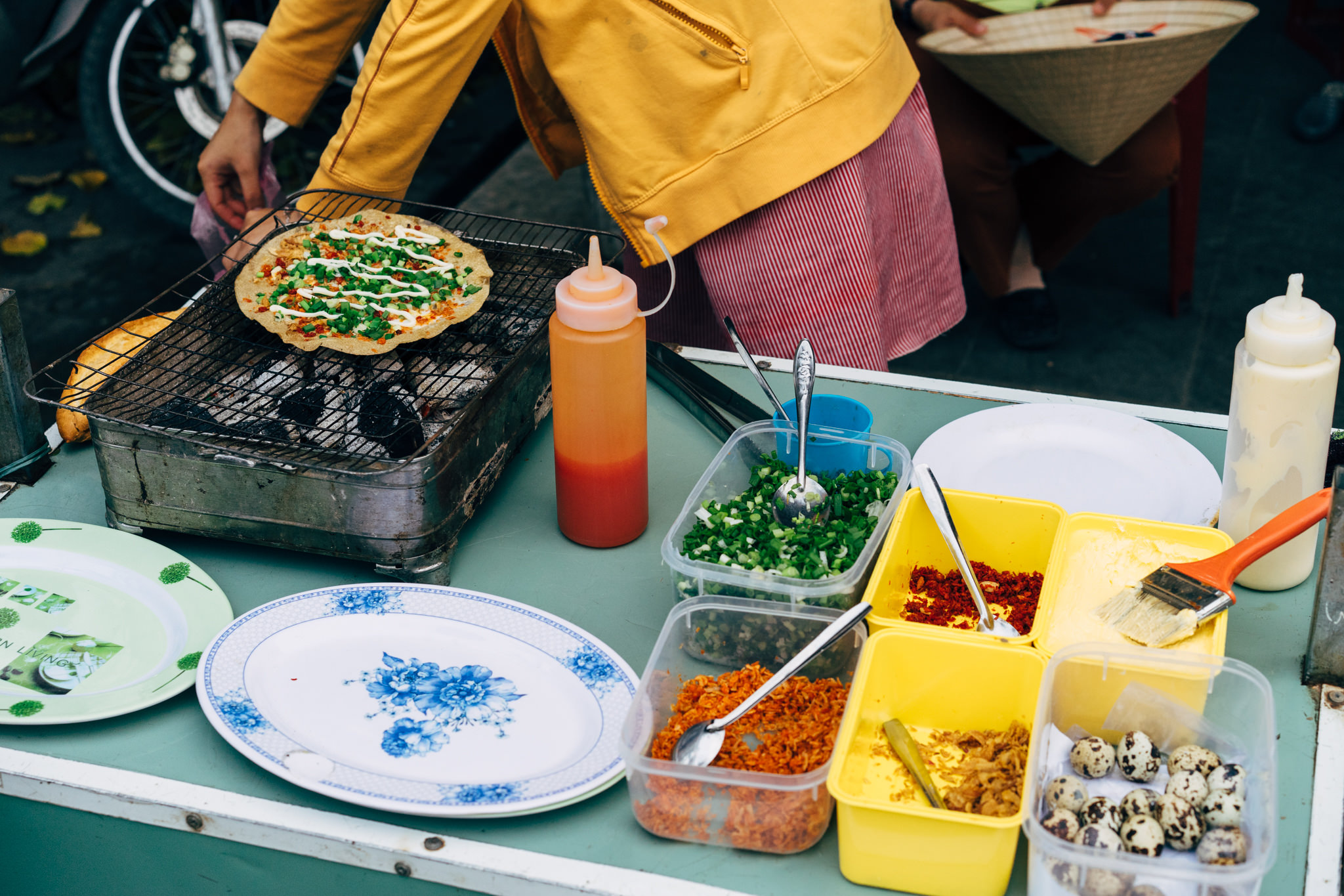Ban xeo being cooked on a street food grill in Hoi An, Vietnam.