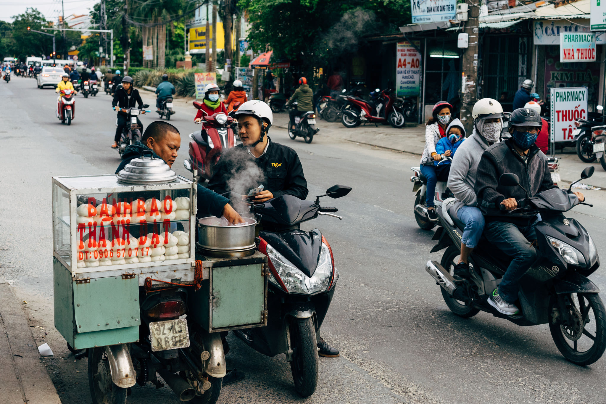 Street food vendor on a motorbike selling banh bao in Hoi An, Vietnam.