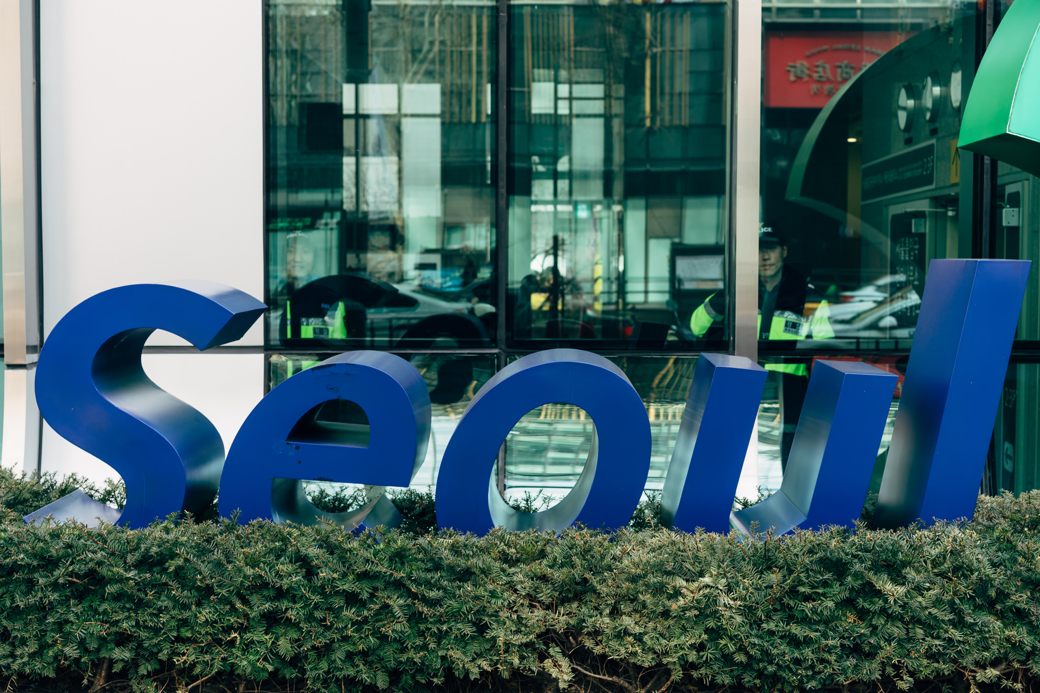 Large blue 'Seoul' sign in front of a building.