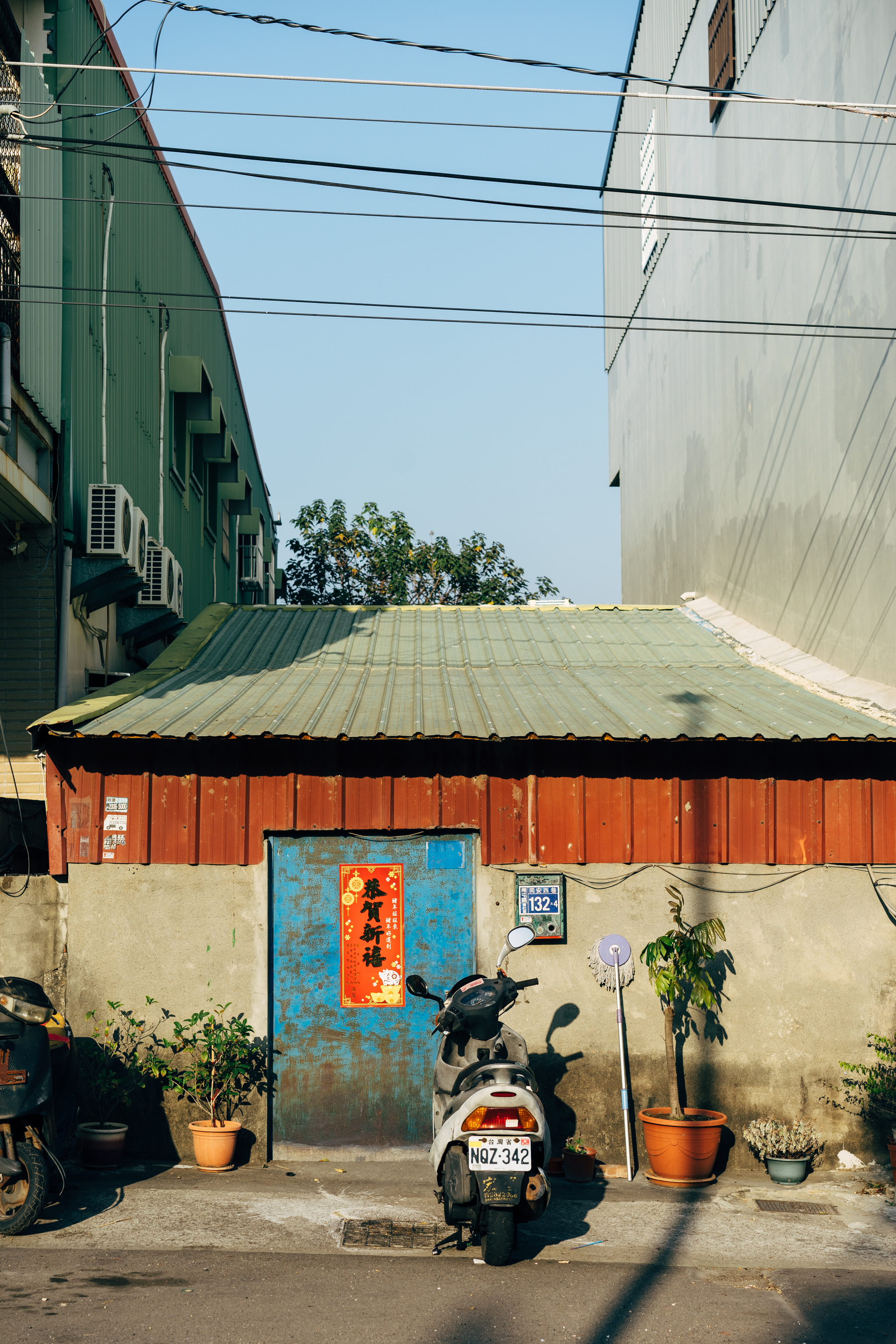 Scooter parked in alley between buildings.