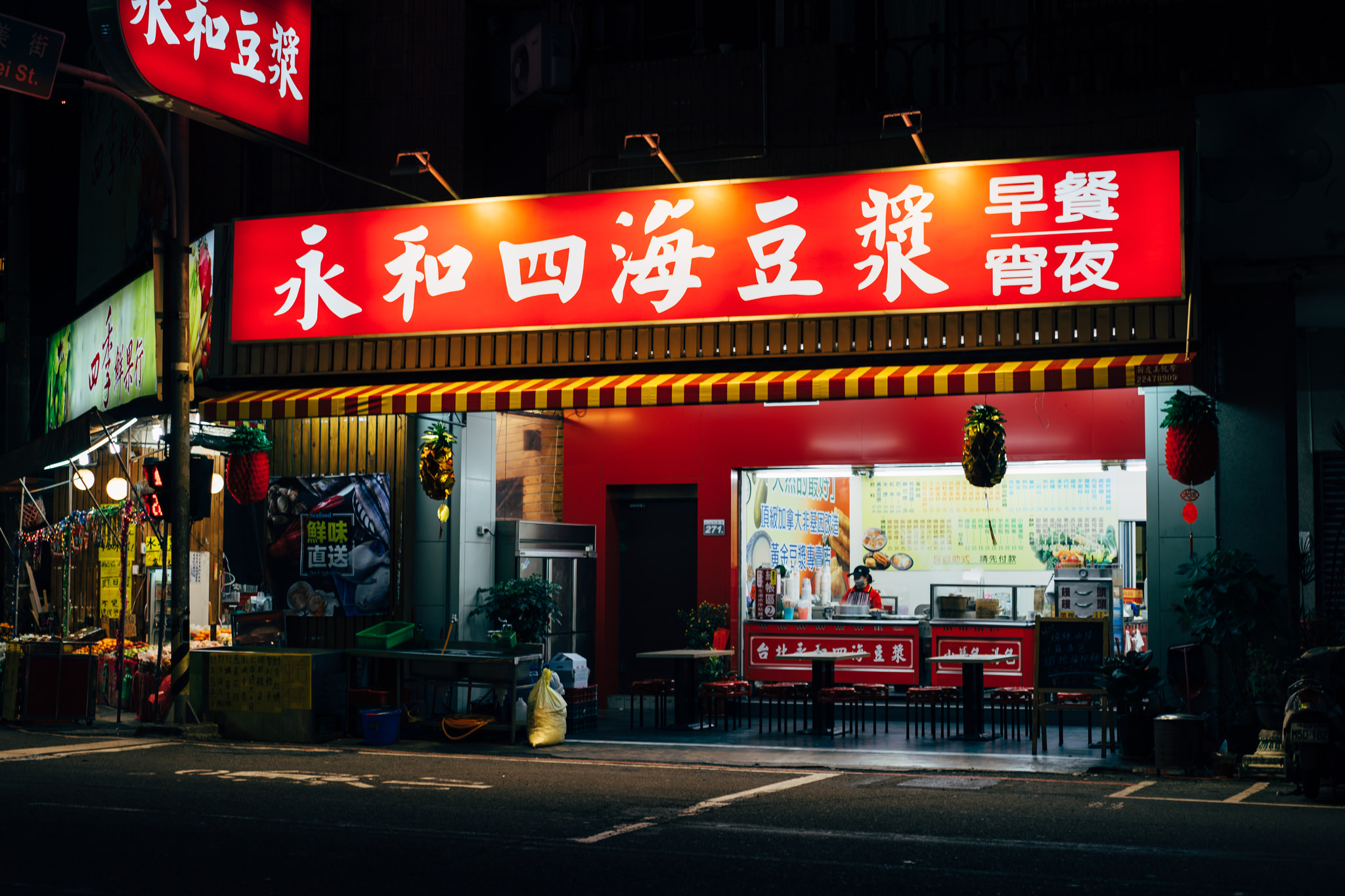 Nighttime view of a brightly lit restaurant in Taichung City, Taiwan, with a red sign in Chinese characters.