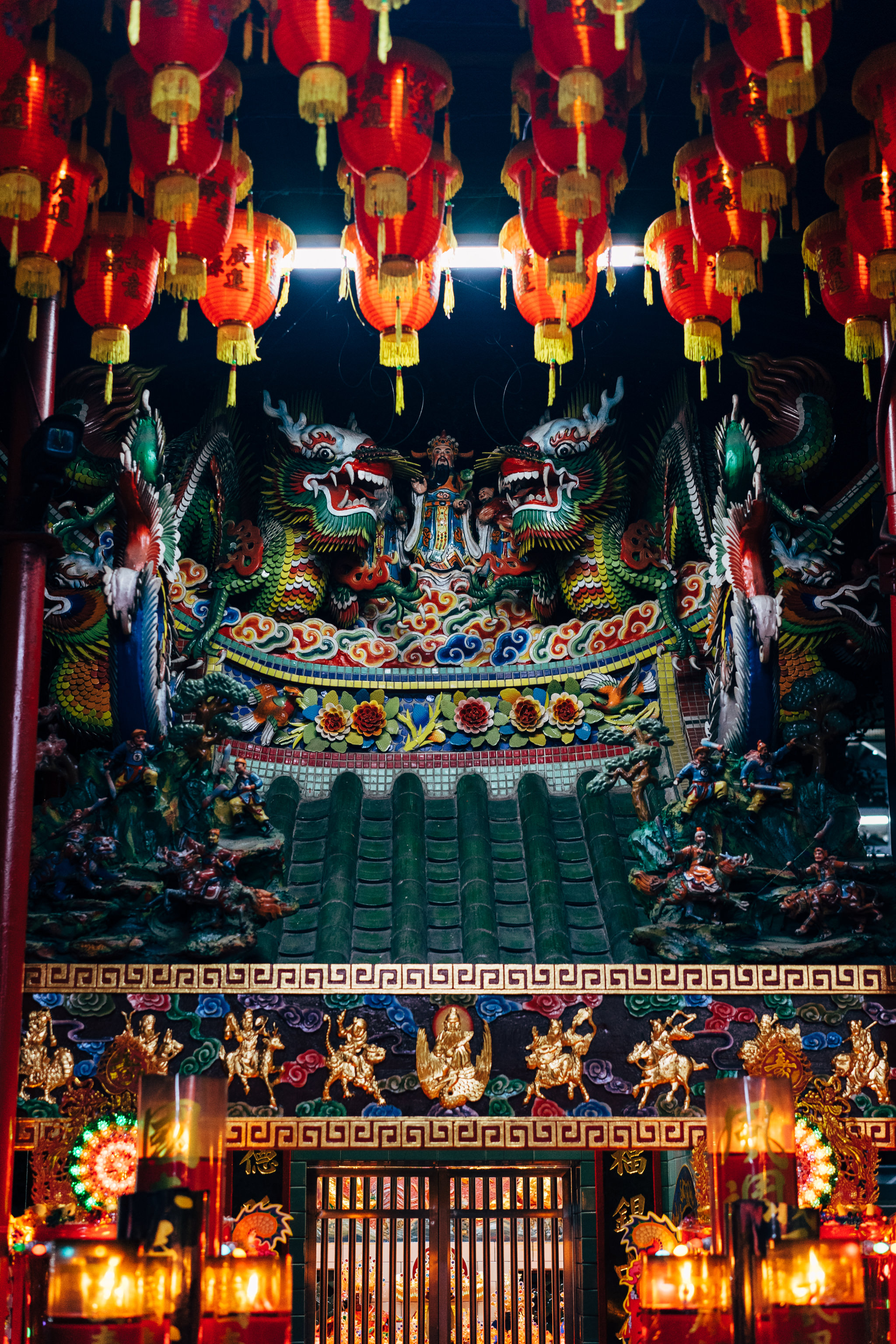 Intricate temple facade with dragons, lanterns, and deity statues.