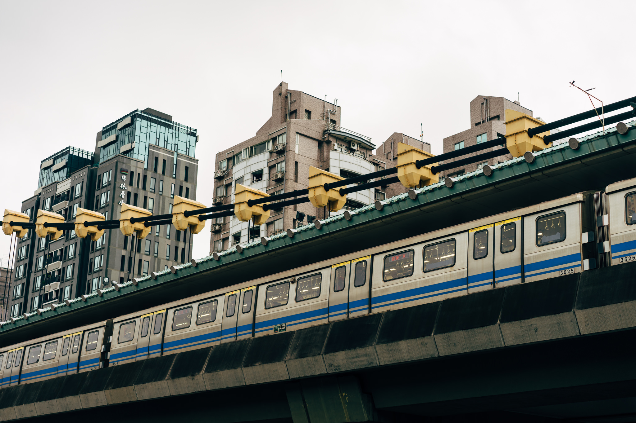 Taipei City, Taiwan: elevated train passing apartment buildings.