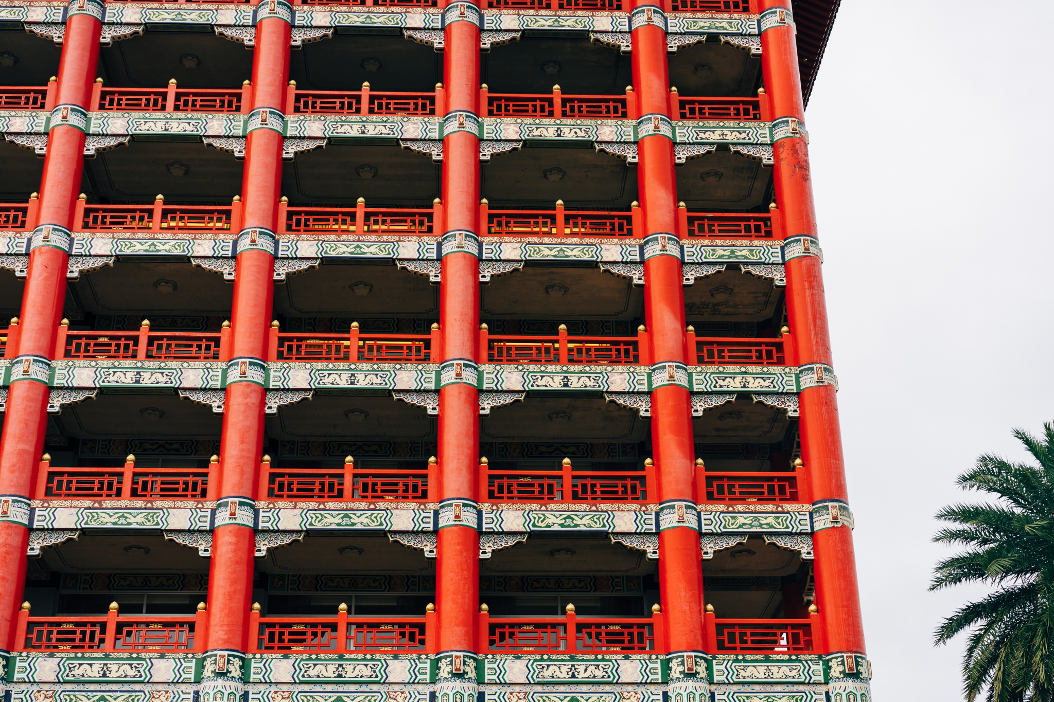 Close-up of Taipei Grand Hotel's red facade with ornate balconies and pillars.