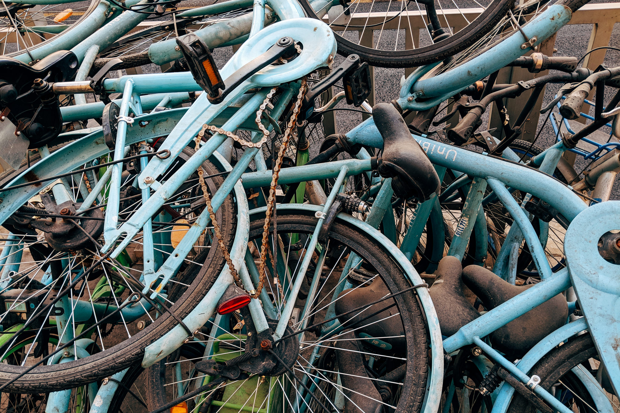 Pile of discarded light blue shared bicycles in China.
