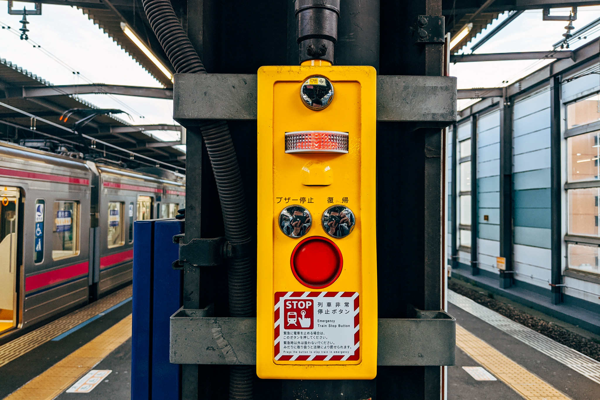 Yellow emergency train stop button with red button.