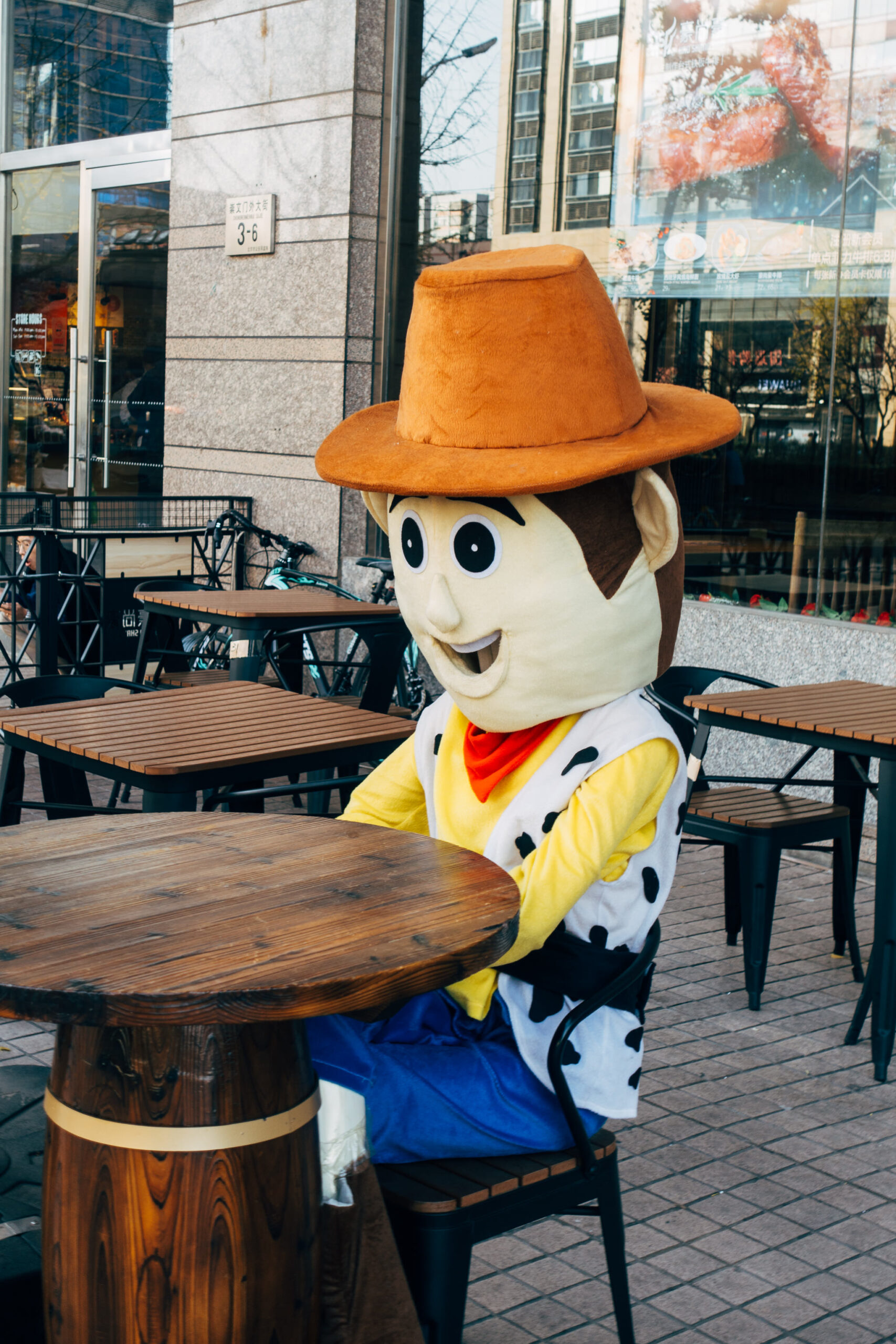 Cowboy mascot sitting at an outdoor table.