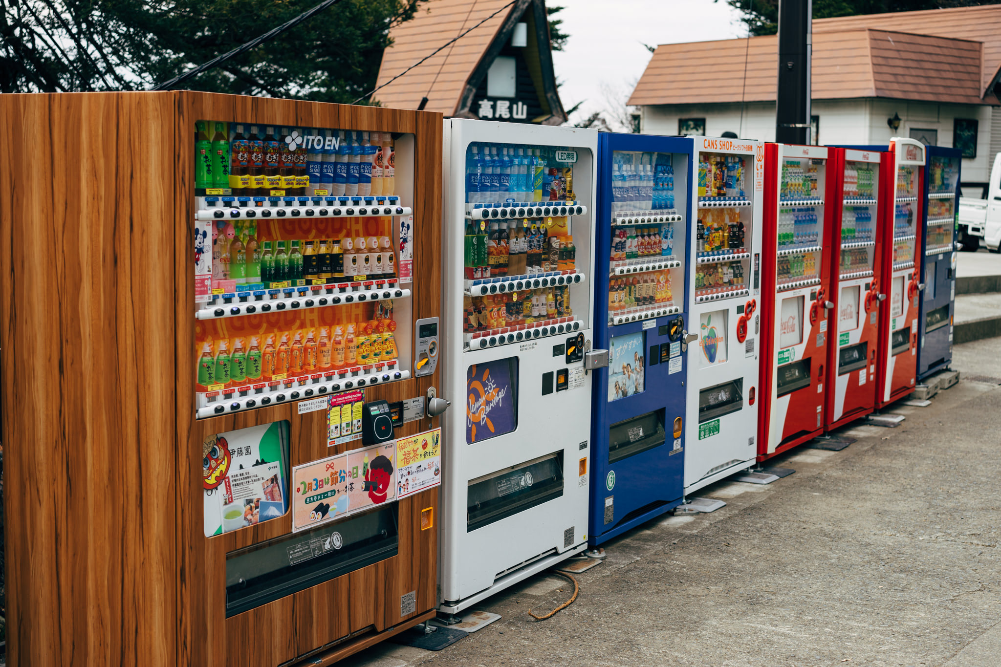 Row of Japanese vending machines dispensing beverages.