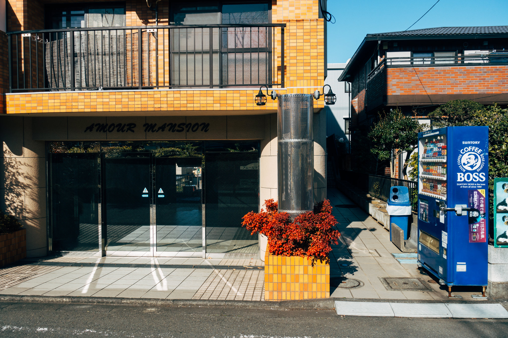 Japanese apartment building entrance with vending machine.