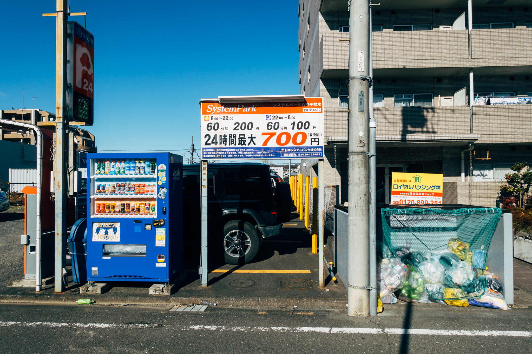 Japanese vending machine and parking lot; parking rates are displayed.