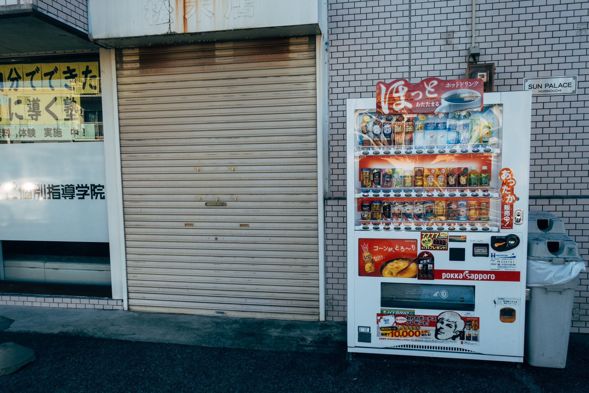 Japanese vending machine stocked with beverages and snacks.