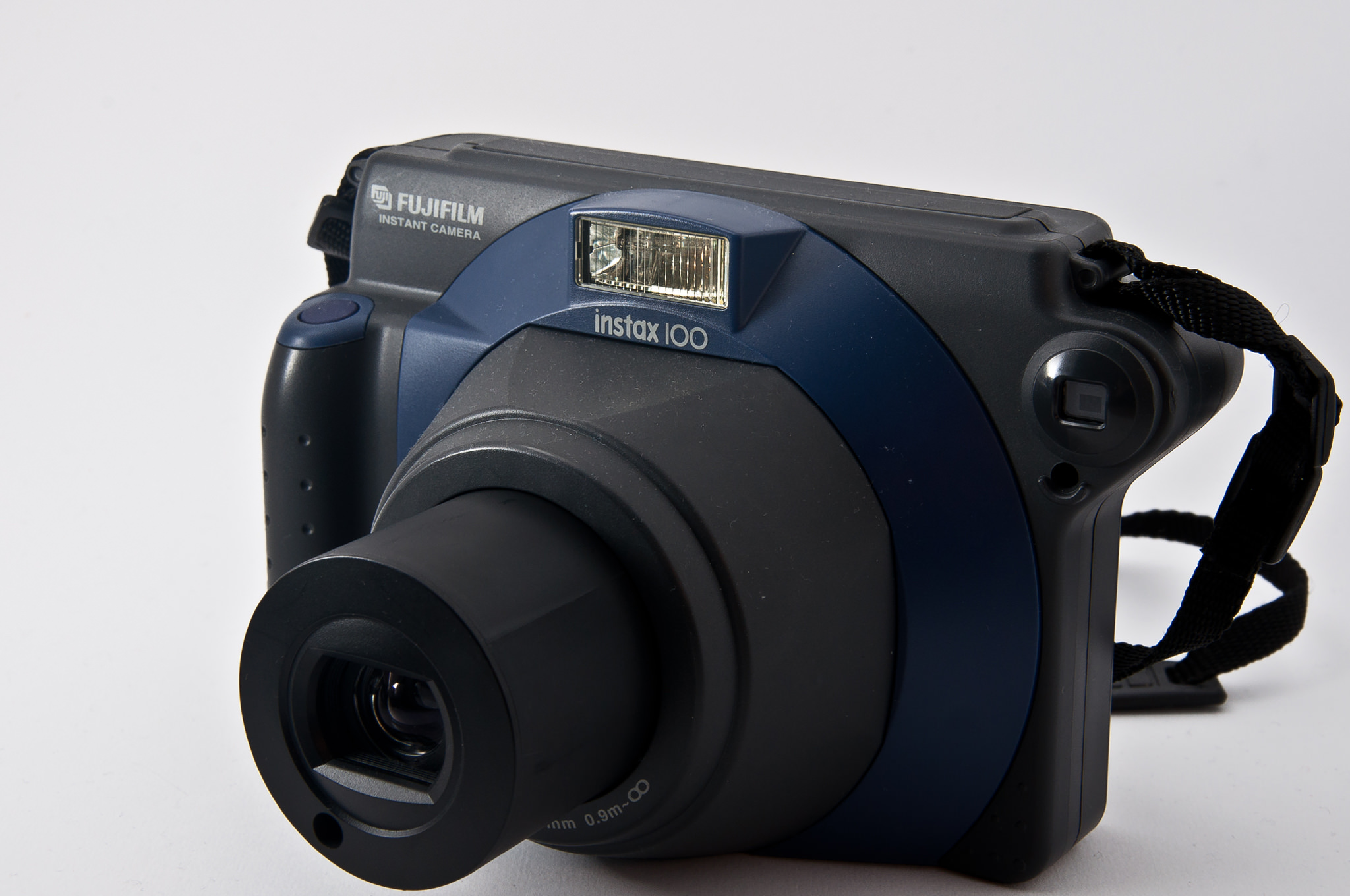 Fujifilm Instax 100 instant camera with a dark blue and black body.