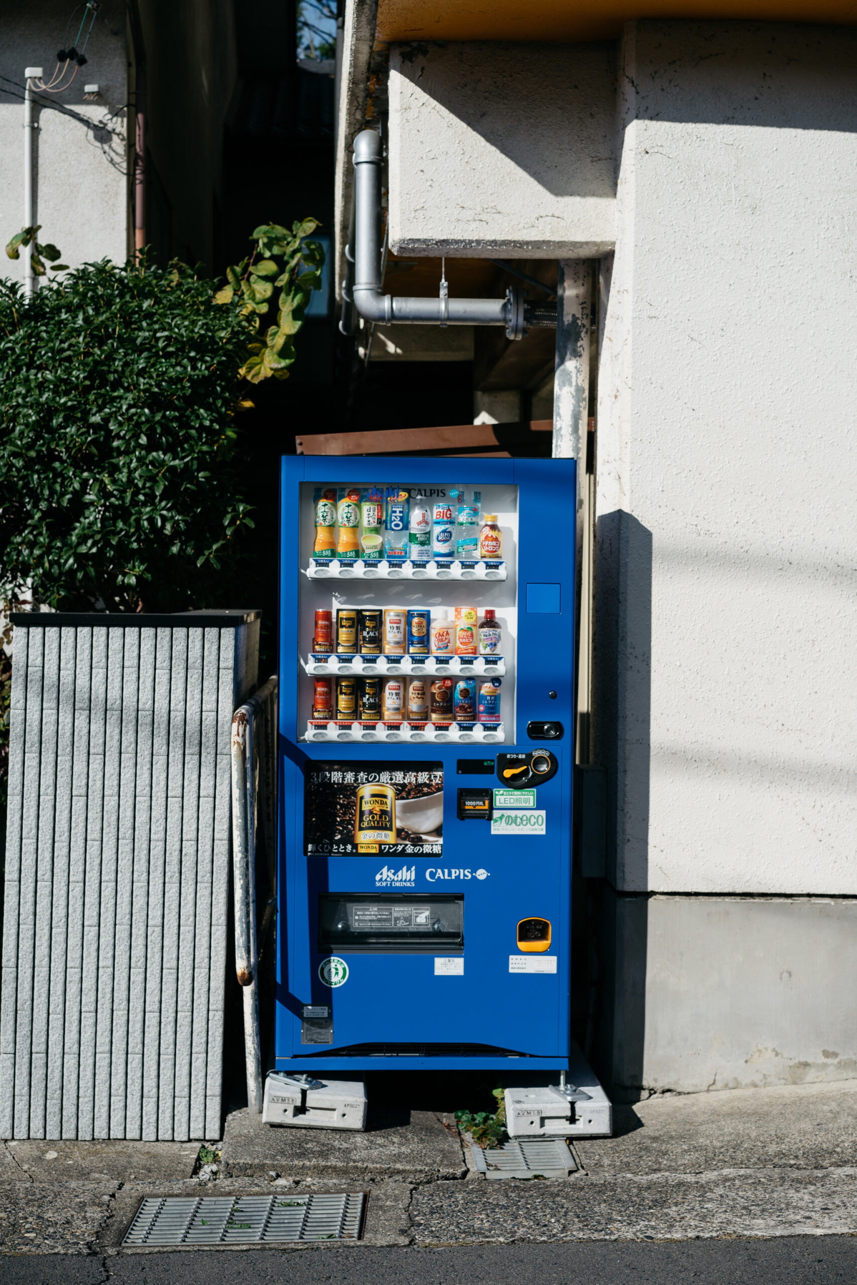 Blue vending machine stocked with various drinks and coffee.