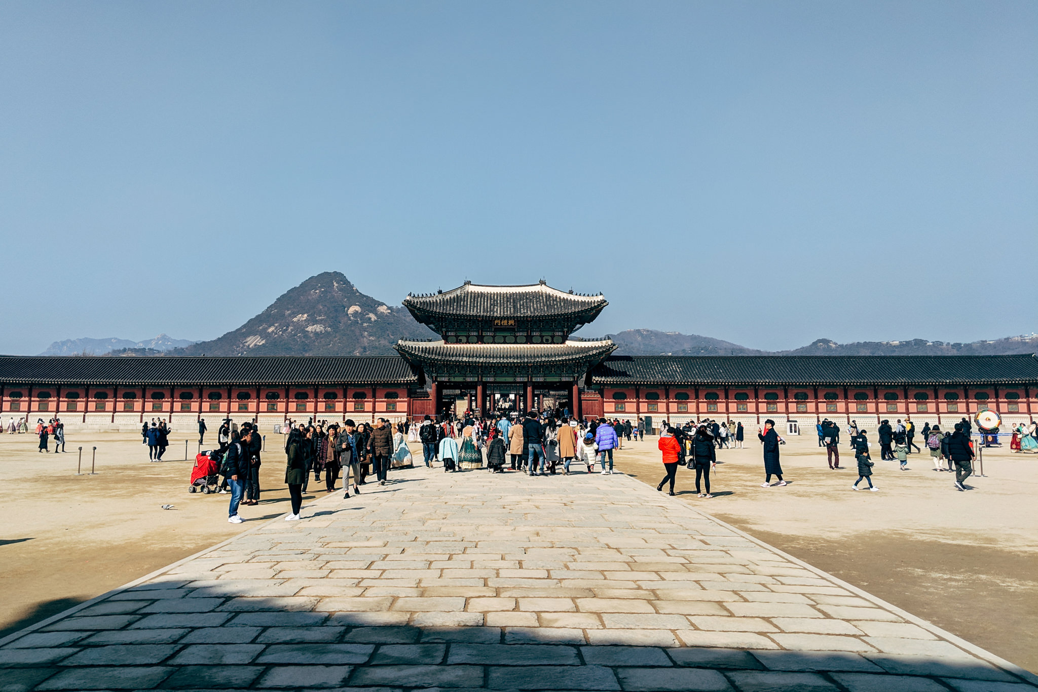 Gyeongbokgung Palace gate and courtyard with many visitors.