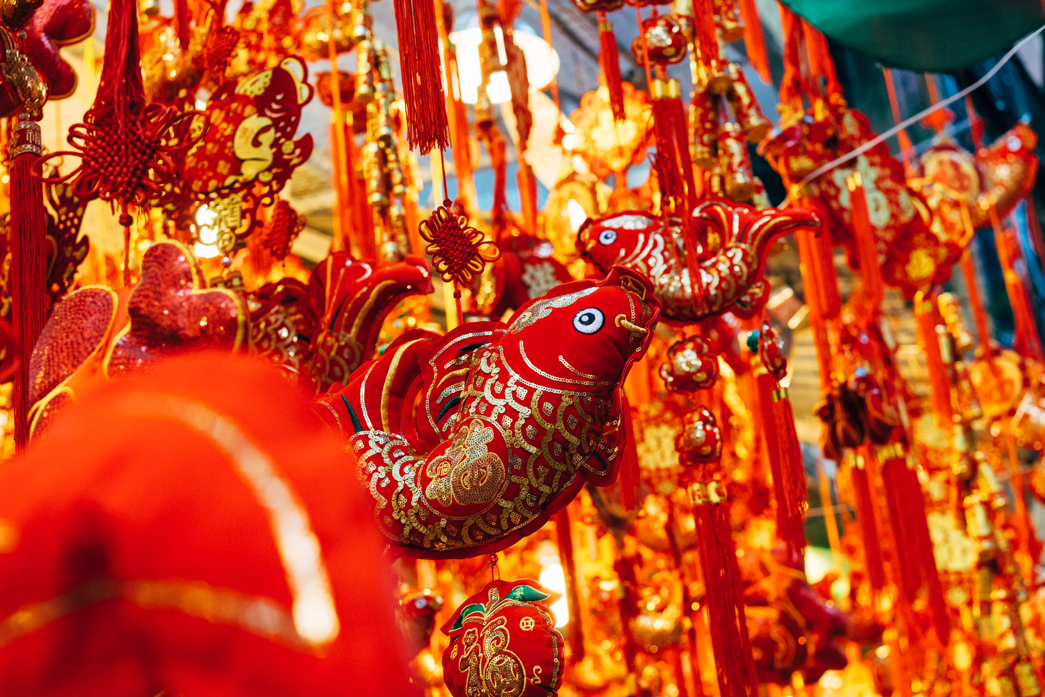 Red and gold Chinese New Year decorations, including fish-shaped ornaments and tassels.