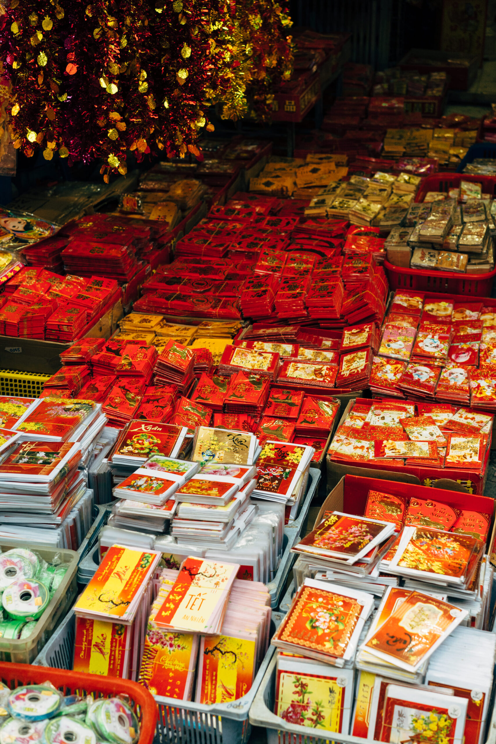 Stacks of red and gold holiday envelopes and cards for sale.