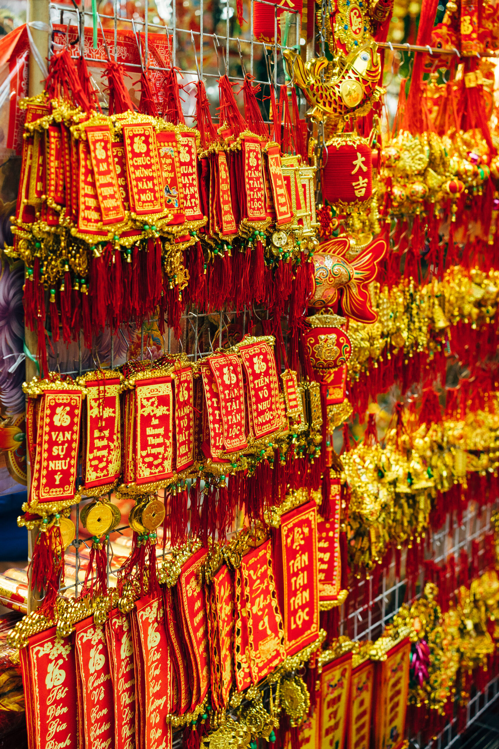 Red and gold Vietnamese New Year decorations hanging on a rack.