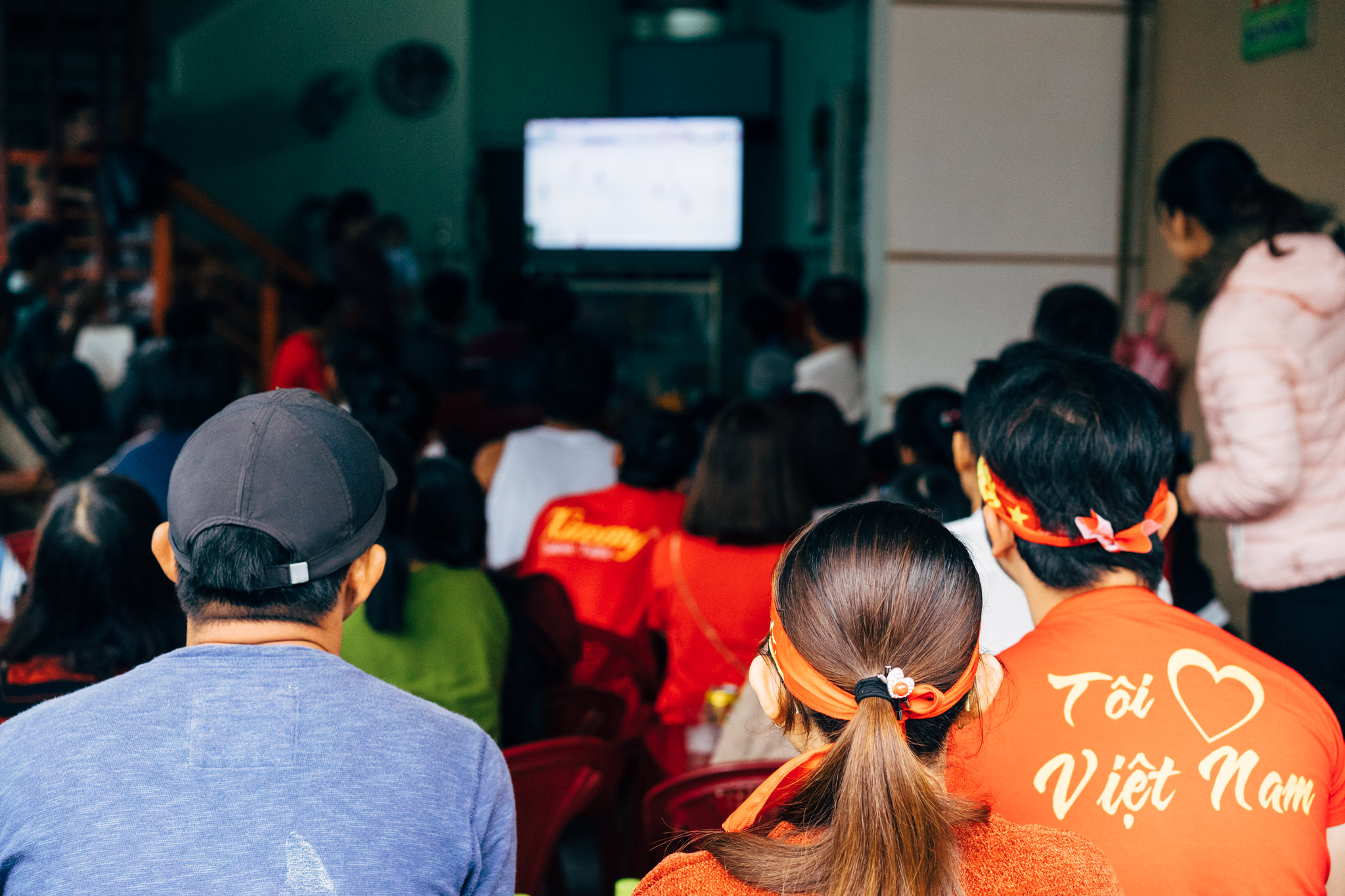 Crowd watching soccer game on TV in Vietnam.