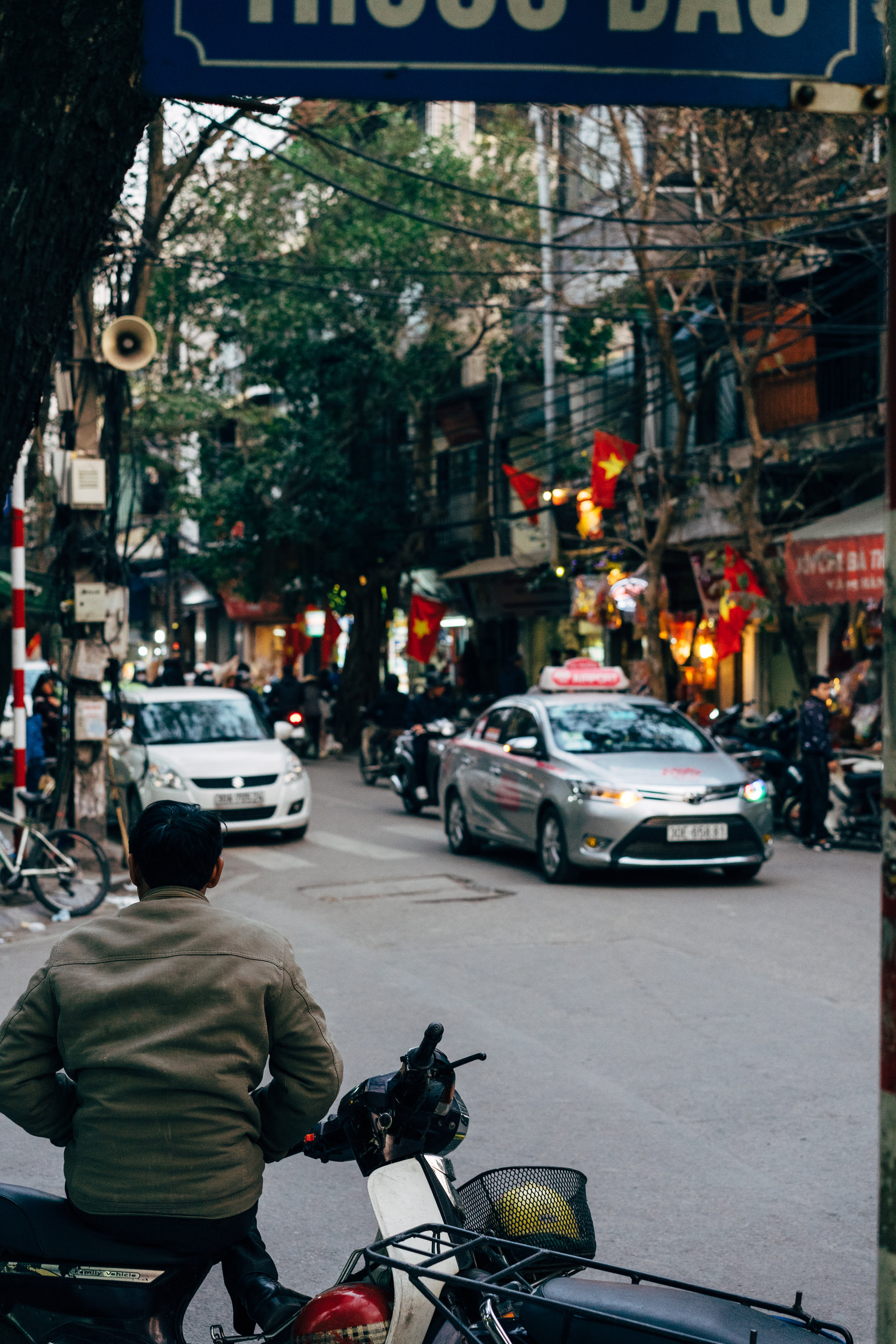 Person on scooter in busy Hanoi street.